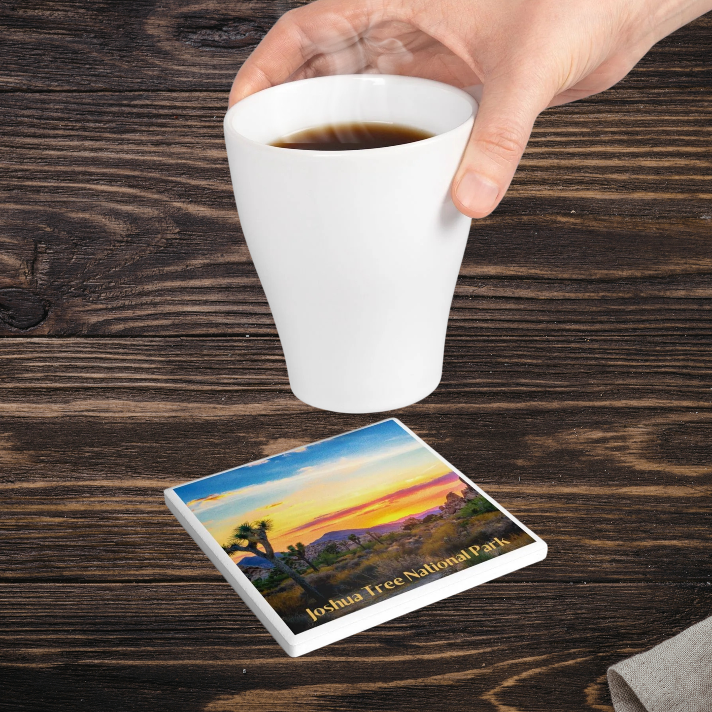 Coaster with Joshua Tree National Park design on a wooden table with a cup of coffee.