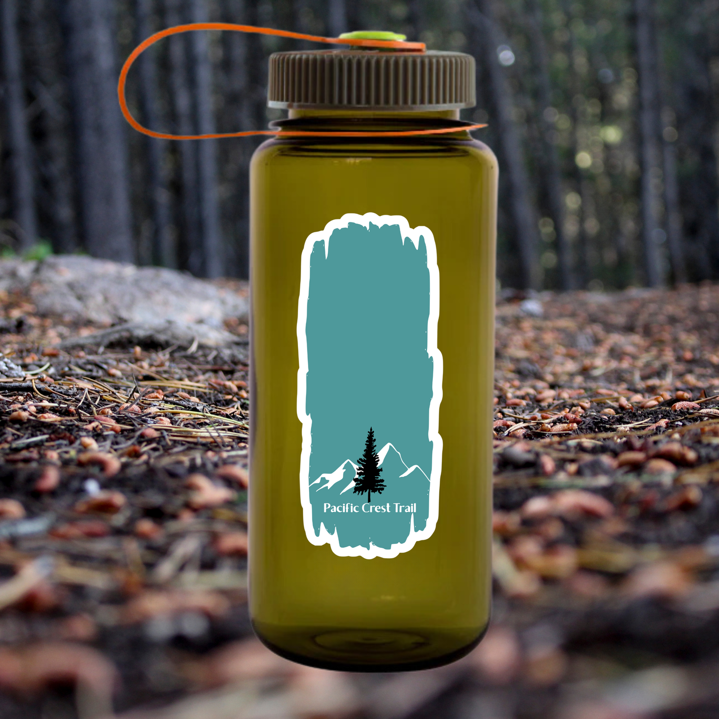 Blue and white Pacific Crest Trail vinyl sticker with the text “Pacific Crest Trail” and a tree and mountain design affixed to a Green water bottle that’s sitting on a forest floor background
