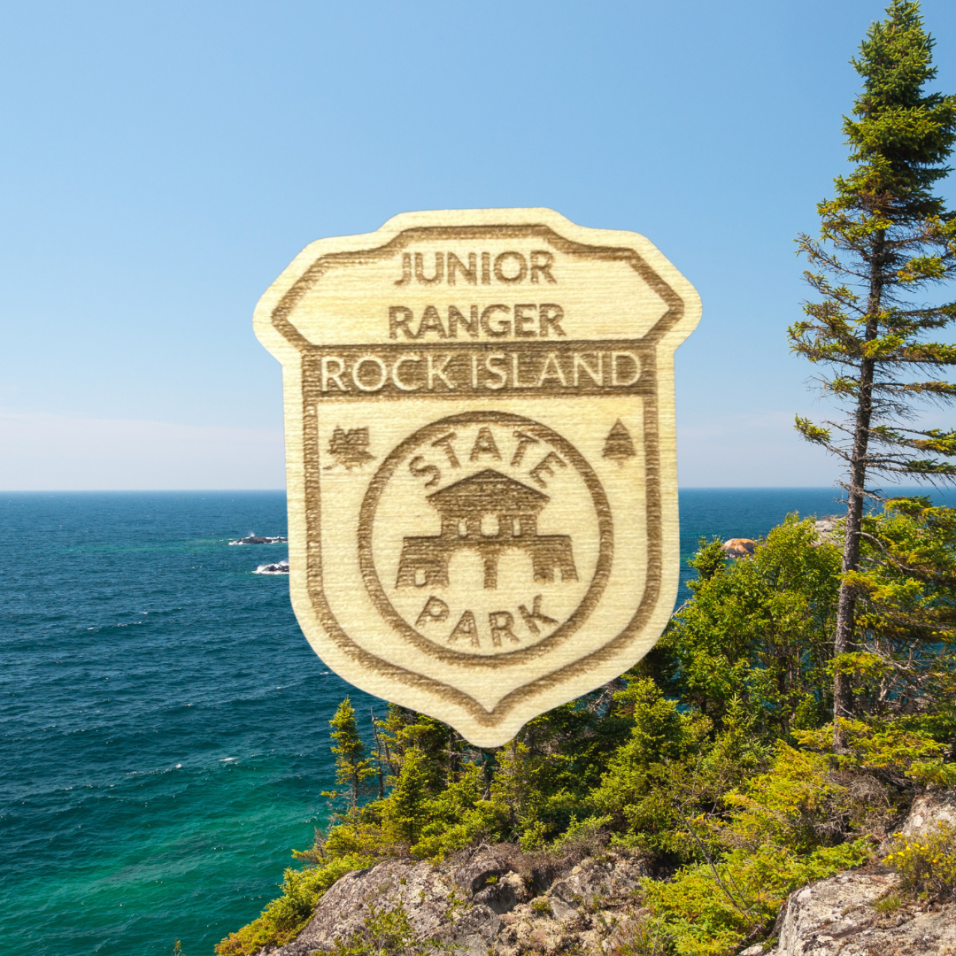 Wood Jr Ranger badge with the text: Junior Ranger, Rock Island State Park. Photo background: large lake with a rocky shoreline and trees.