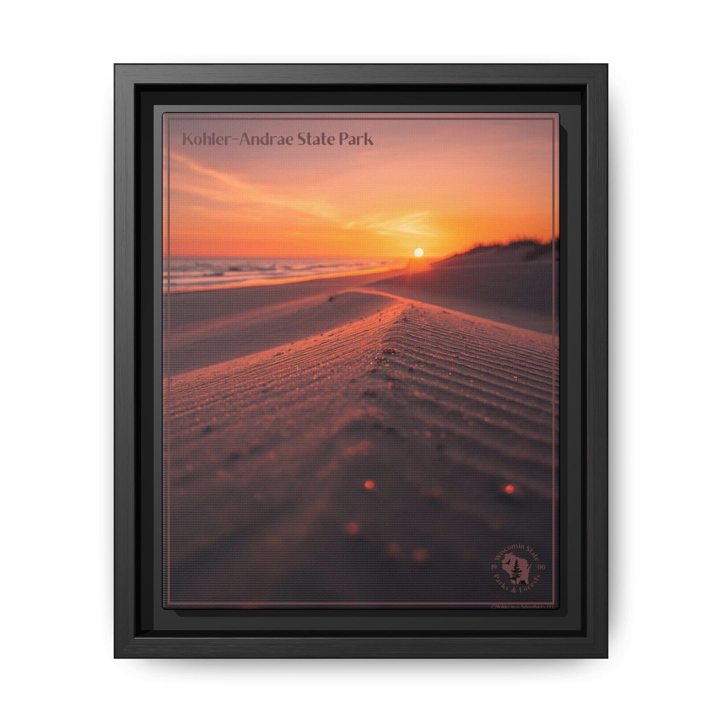 Framed wall print featuring an image of looking down a sand dune at a rising sun over a lake.