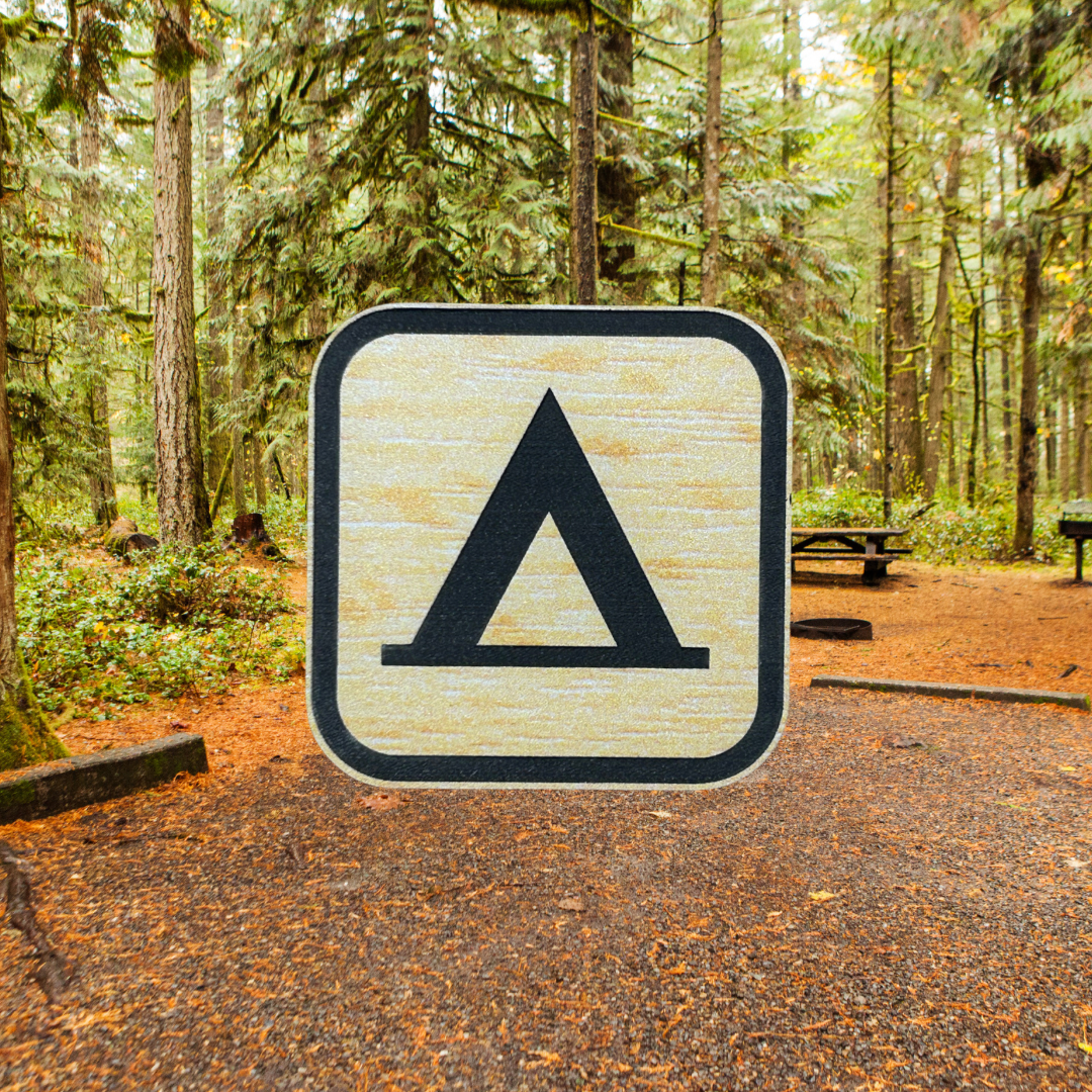 Wood grain acrylic magnet with the national camping recreation symbol. Photo background: rustic campsite among the pines.