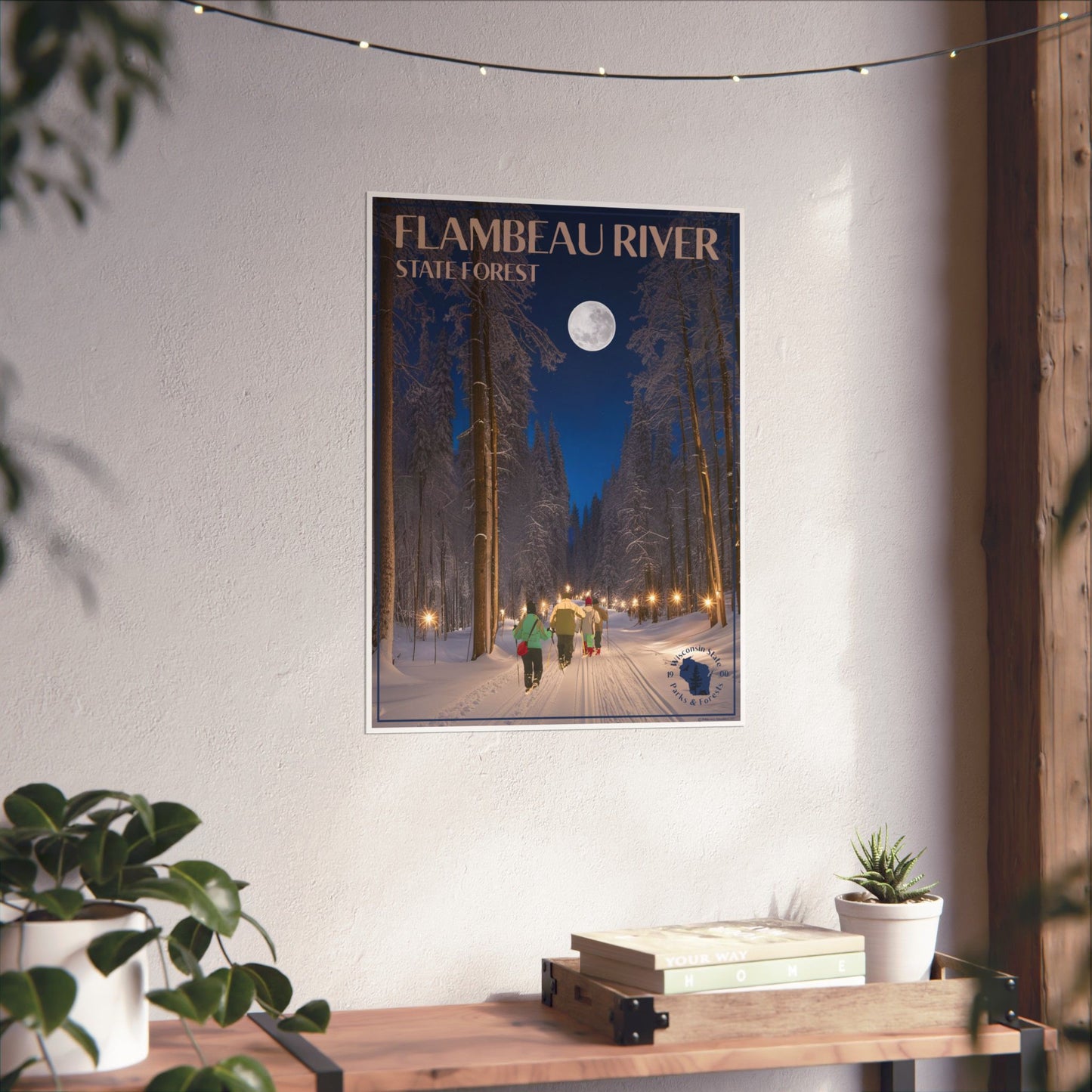 Poster of Flambeau River State Forest on a wall above a wooden desk with plants.