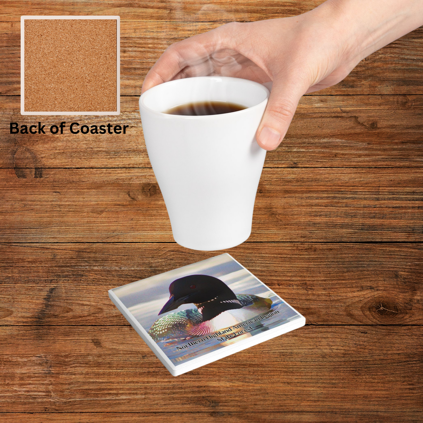 Ceramic coaster featuring an up close photo of a loon and iridescent feather colors with the text “Northern Highland American Legion State Forest”. Photo background: coaster on a wood table with a person placing a hot beverage on it and the a photo of the backside of the coaster.