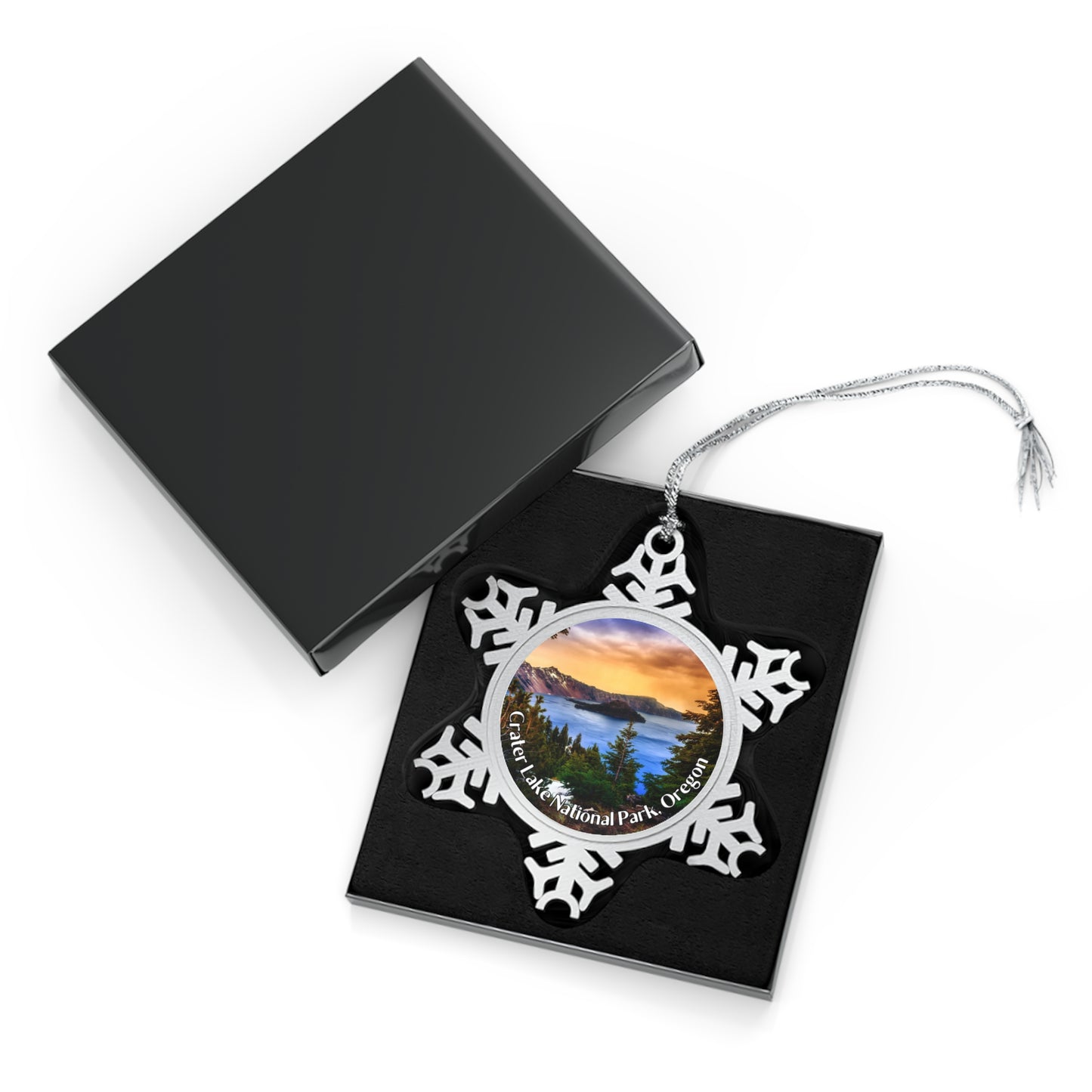 Pewter snowflake ornament with a sunrise over Crater Lake design in a black display box.