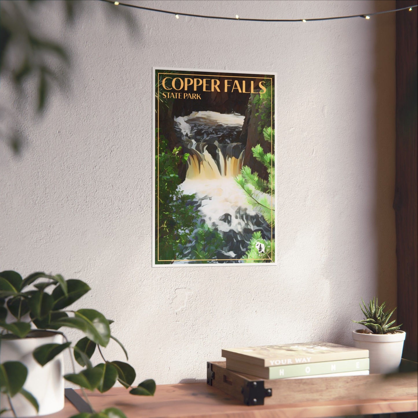 Poster featuring the namesake of Copper Falls State Park: Copper Falls as it flows into the gorge. Photo background: poster hanging on a wall above a wood shelf with books and plants.