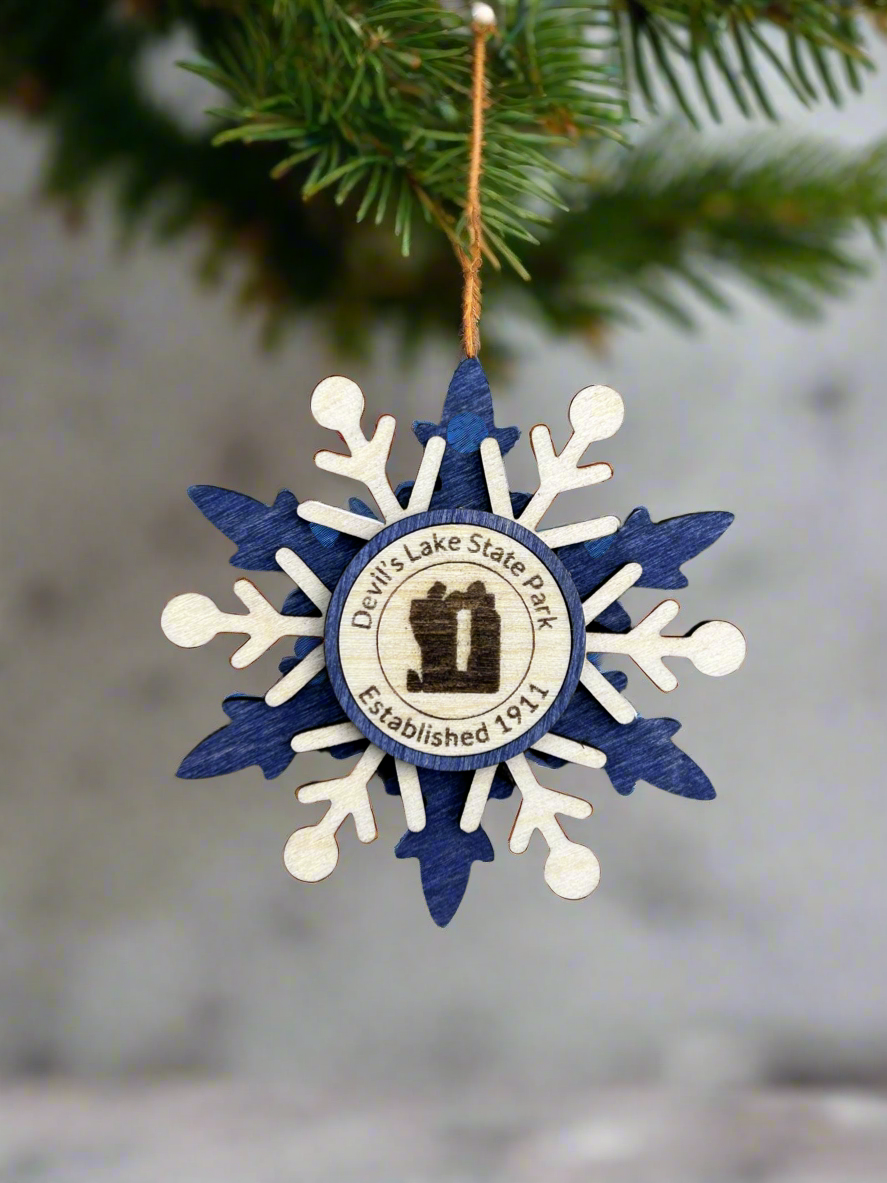Blue wood snowflake ornament with text Devil's Lake State Park and Devil's Rock symbol.