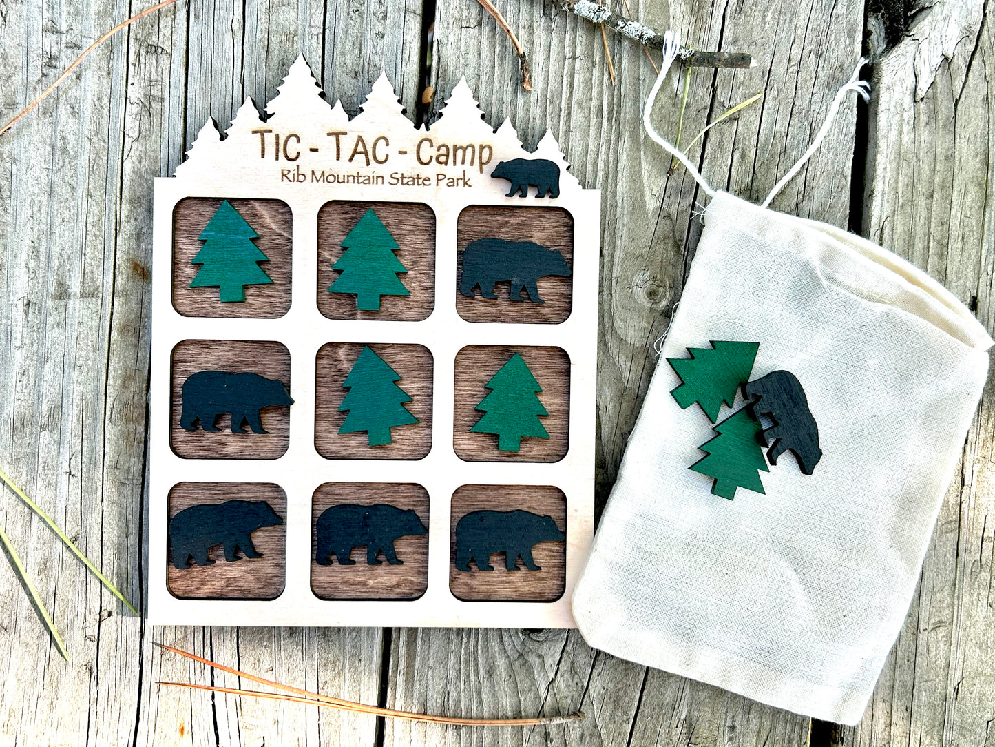Wood tic-tac-toe board game with bear and tree shaped playing pieces.