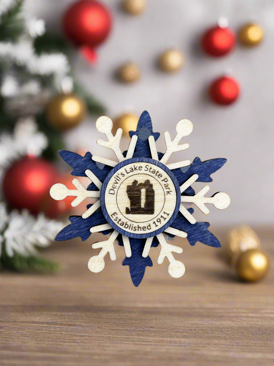 Blue wood snowflake ornament with text Devil's Lake State Park and Devil's Rock symbol.