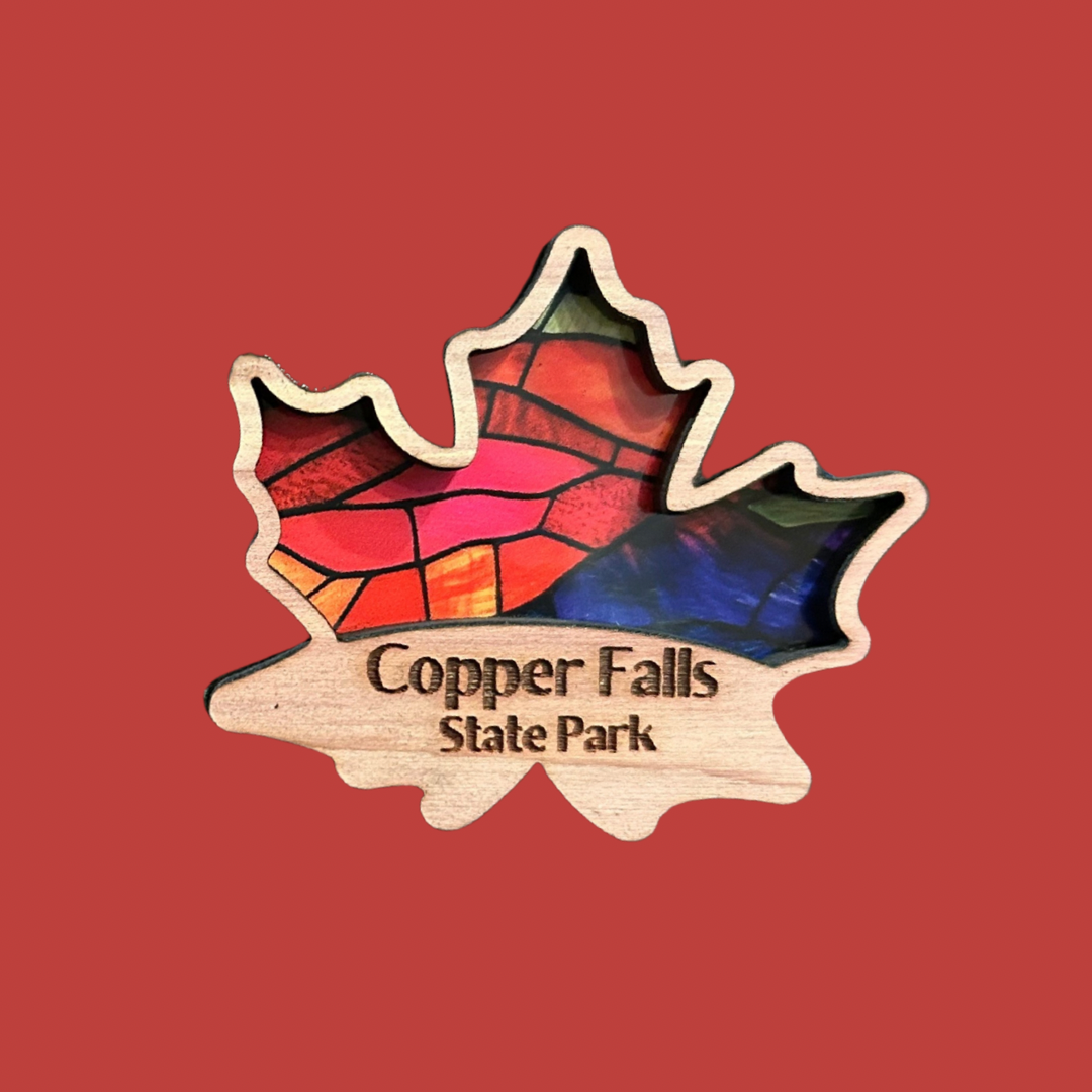 cedar maple leaf shaped magnets with a faux stained glass appearance. Photo Background: solid orange.