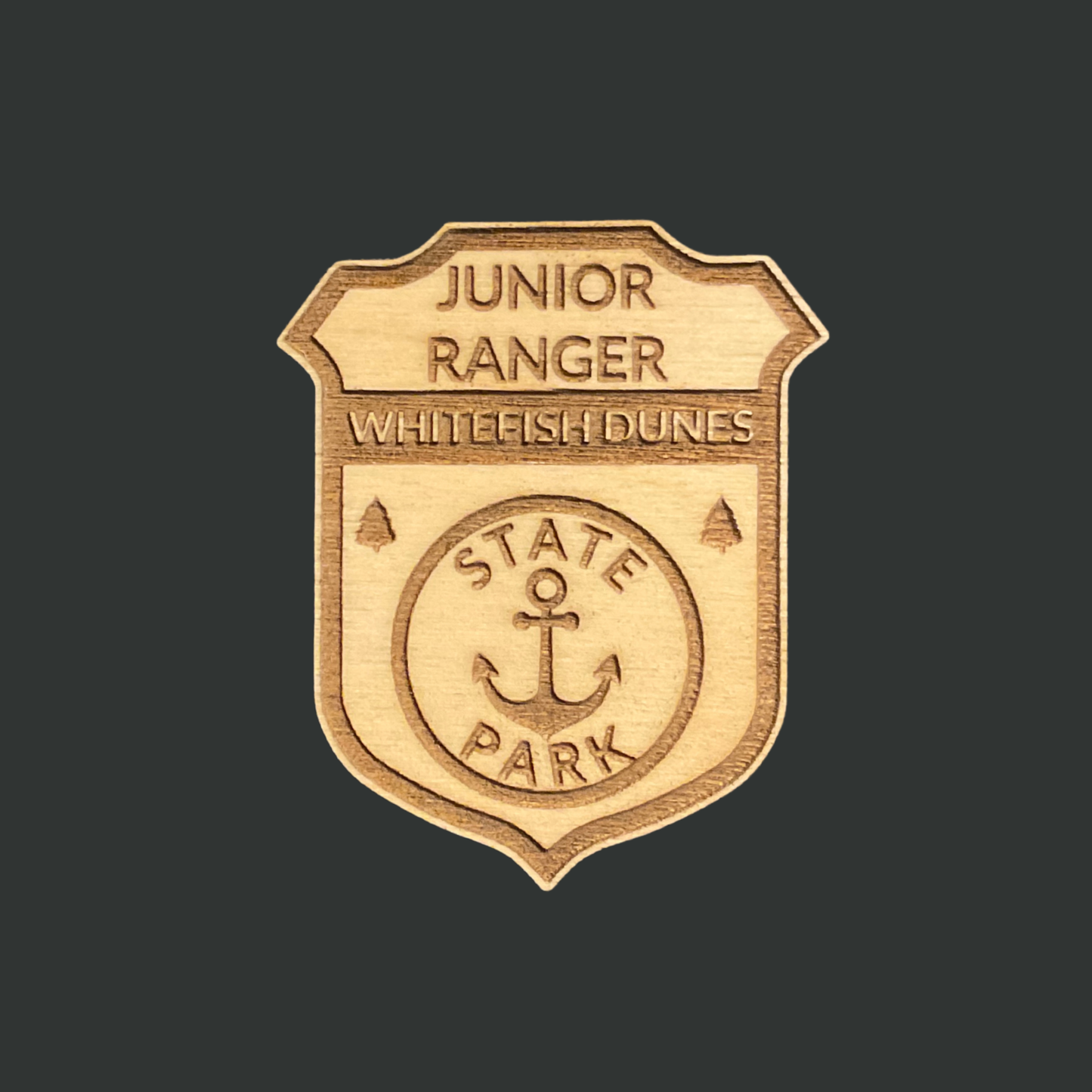 Wooden badge with 'Junior Ranger Whitefish Dunes State Park' text and an anchor icon against a Dark brown background.