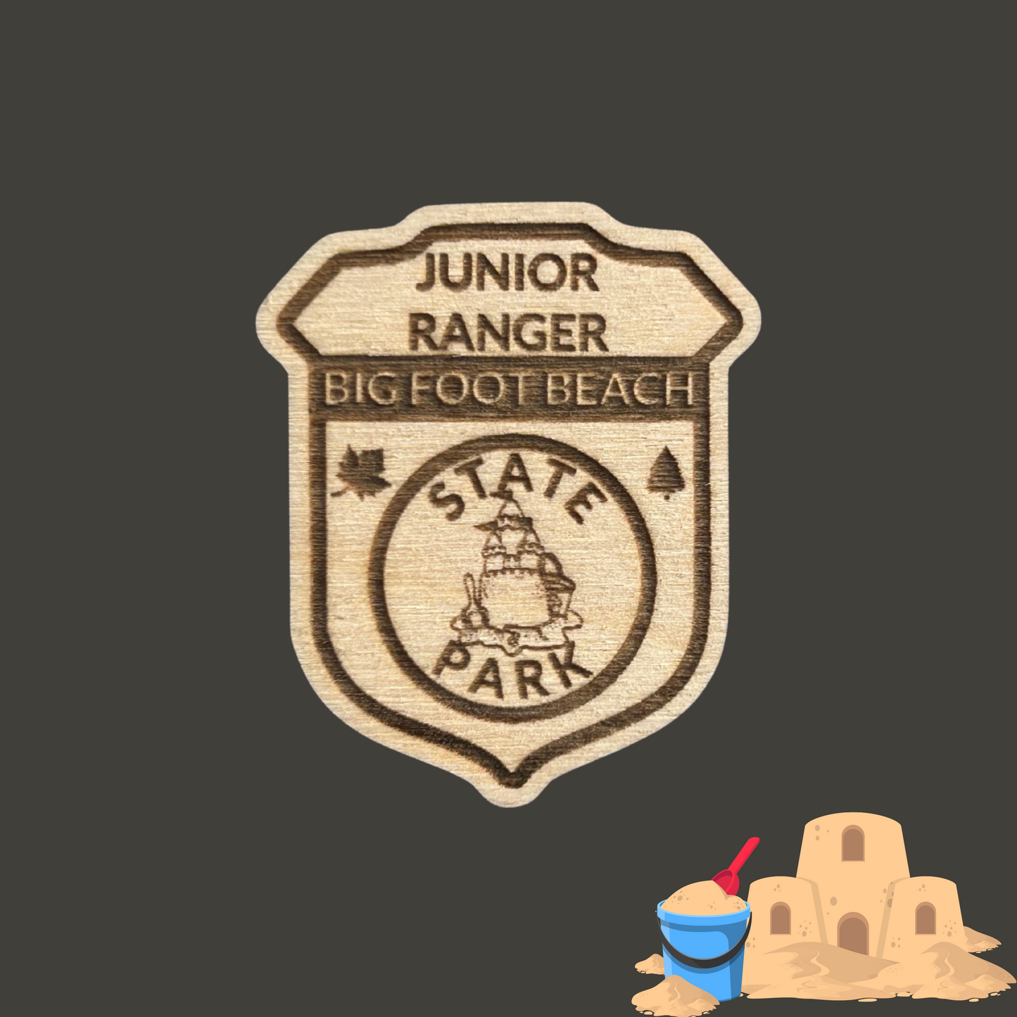 Laser engraved wood badge featuring the text: “Junior Big Foot Beach State Park” with the icon of a sandcastle. Photo Background: dark grey background with clip art image of a sandcastle.