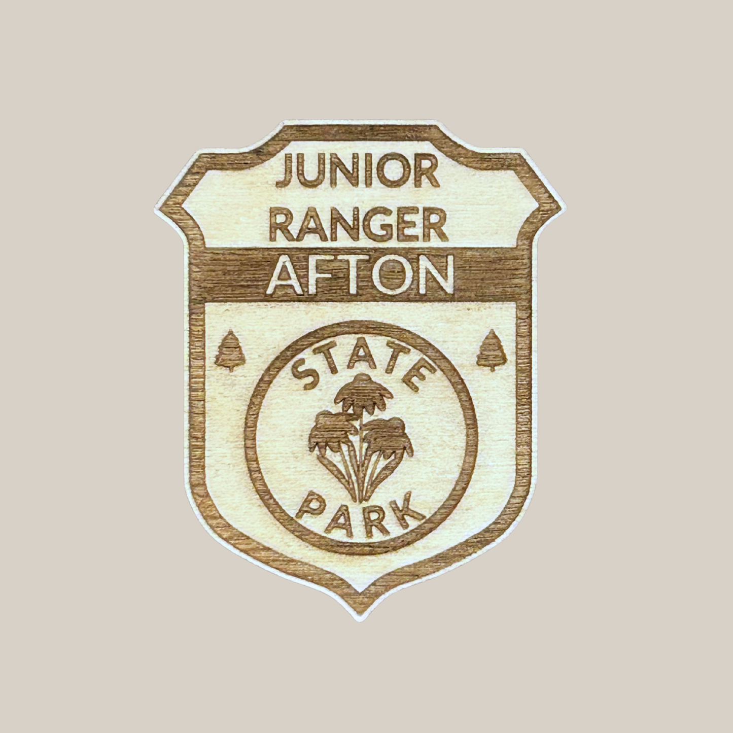 Wood Jr Ranger badge with the text “Junior Ranger Afton State Park” against a beige background.