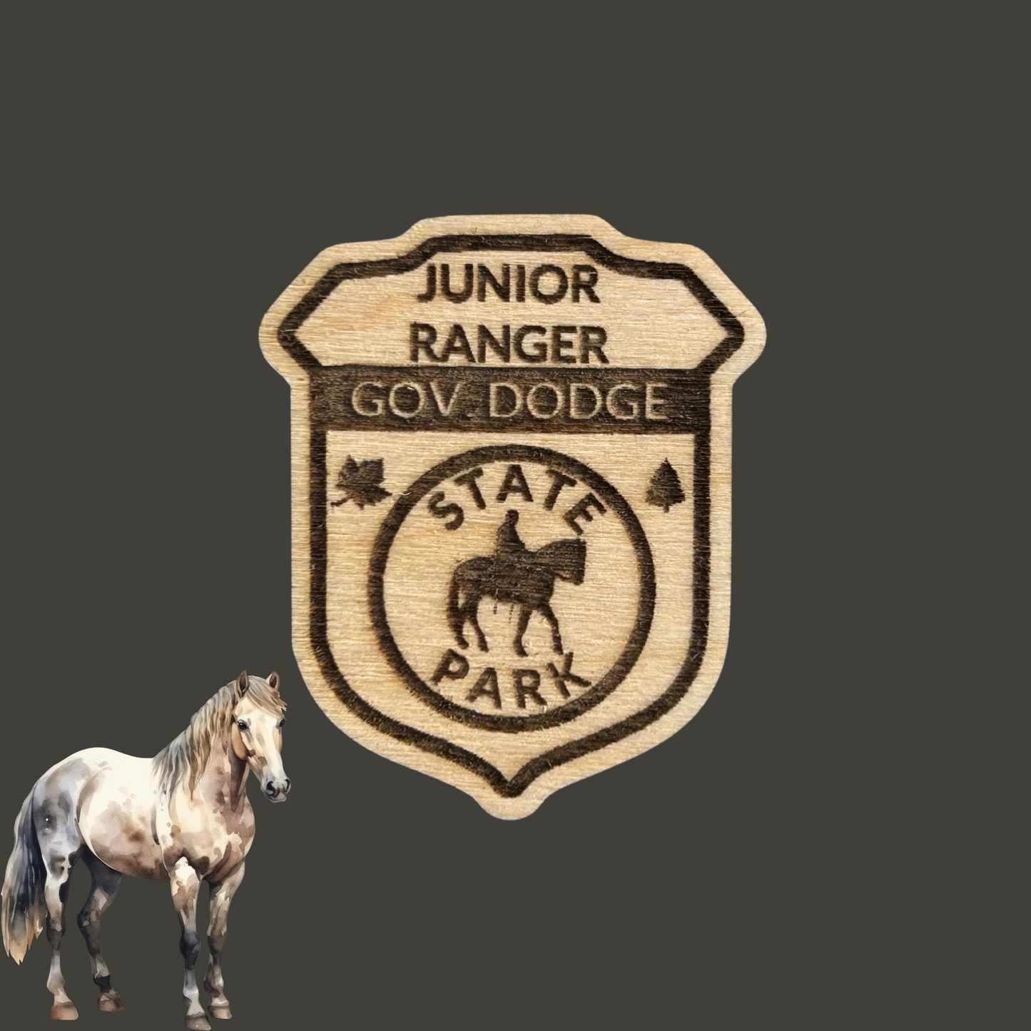 Laser engraved wood badge featuring the text: “Junior Ranger Gov Dodge State Park” with the icon of a person riding a horse. Photo Background: dark grey background with a clip art image of a horse standing.