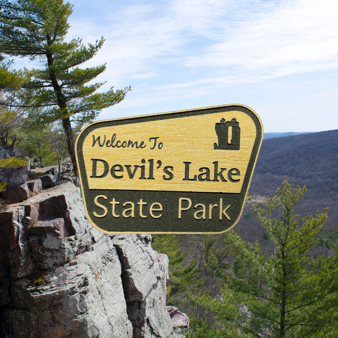 Engraved wood grain acrylic with “Welcome to Devil’s Lake State Park”. Photo background: bluff overlooking a rock ledge and wooded valley.