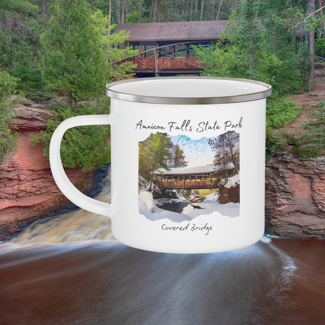 White enamel mug depicting the covered bridge at Amnicon Falls State Park in winter. Background: Amnicon falls.