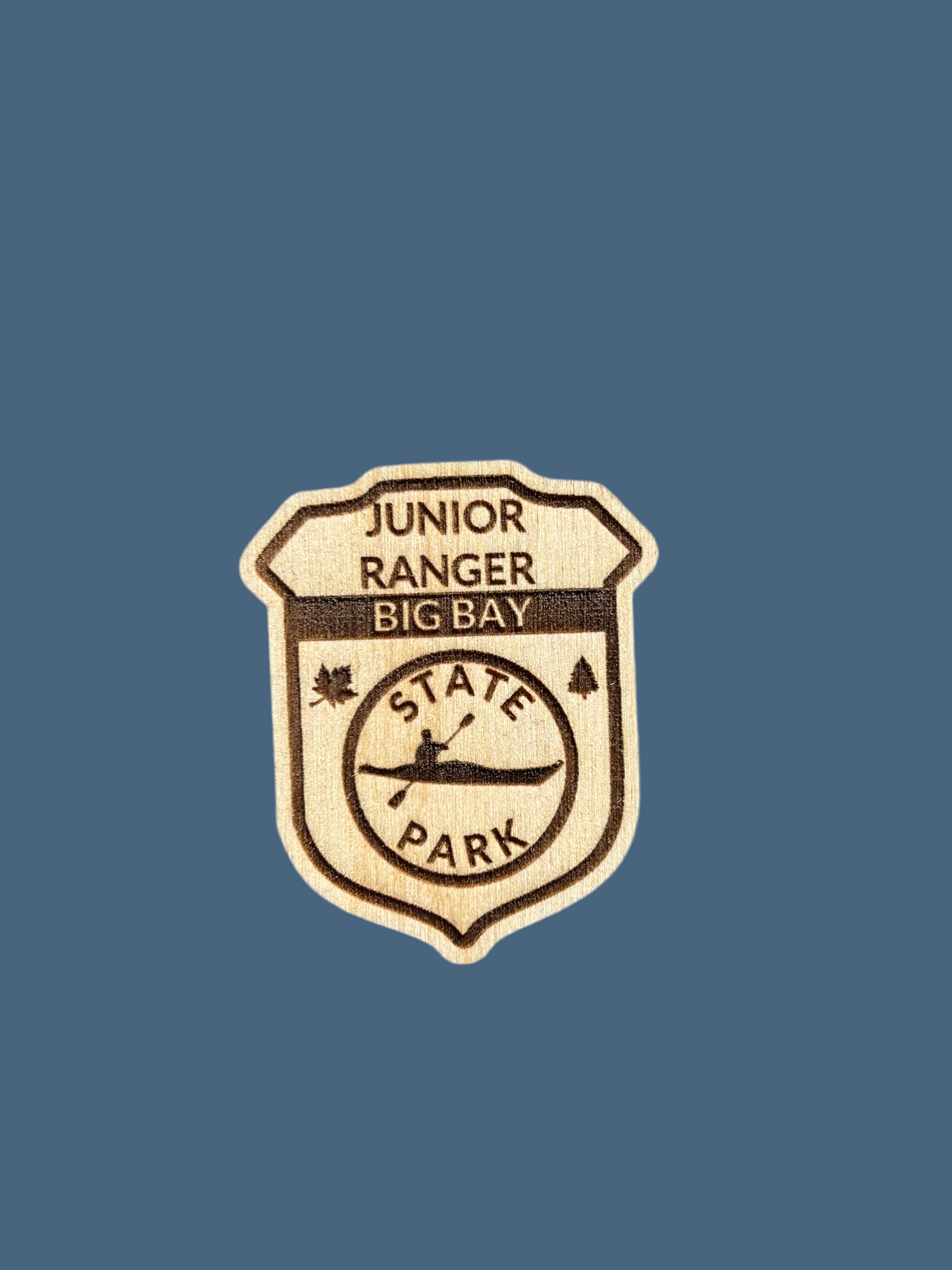 Wood Junior ranger badge depicting Big Bay State Park with a Kayak Symbol.