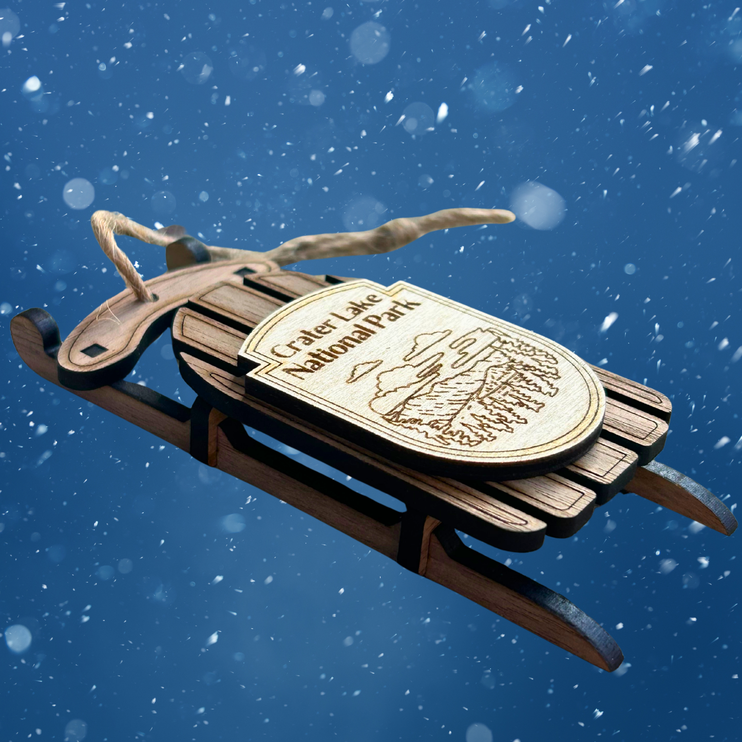 Wooden sled with 'Crater Lake National Park' plaque against a snowy background