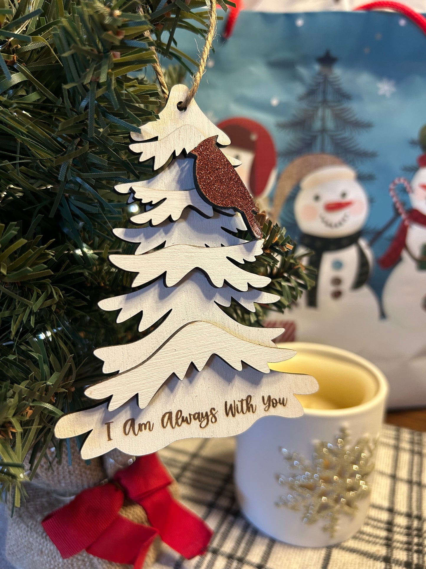 Wood tree ornament with one cardinal in a red glitter color attached and the text I am always with you engraved at the bottom of the tree.