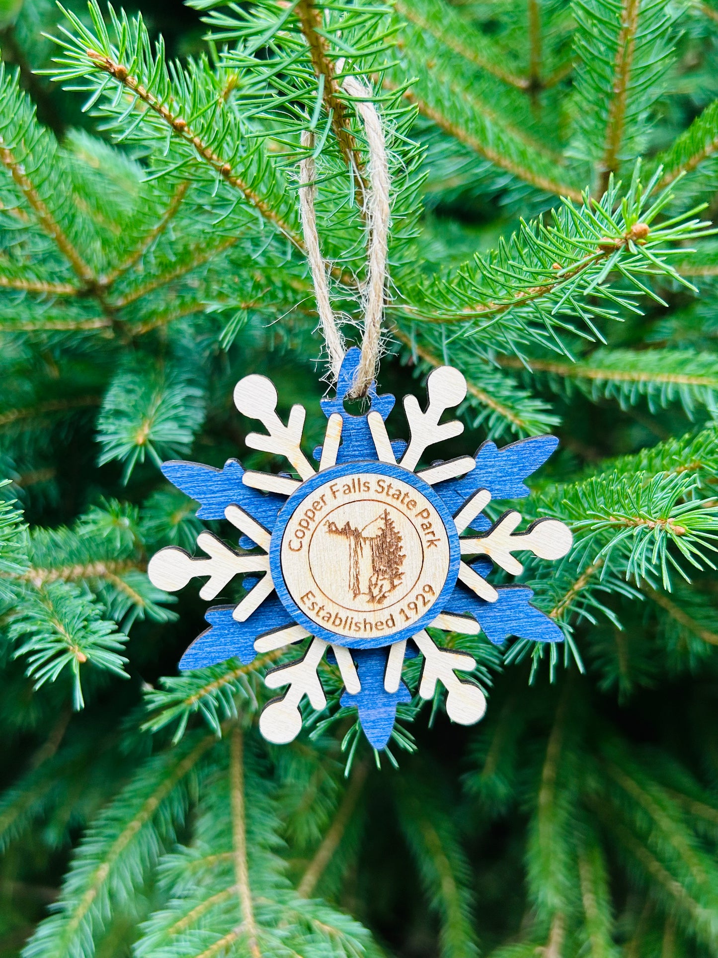 Blue wood snowflake ornament with text Copper Falls and waterfall symbol.