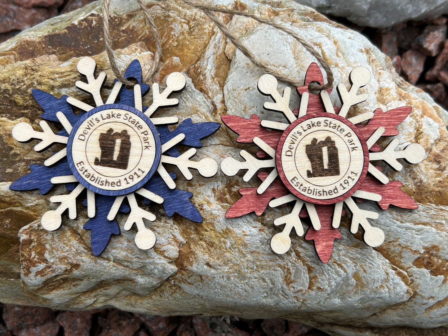 Blue and Red wood snowflake ornaments with text Devil's Lake State Park and Devil's Rock symbol.