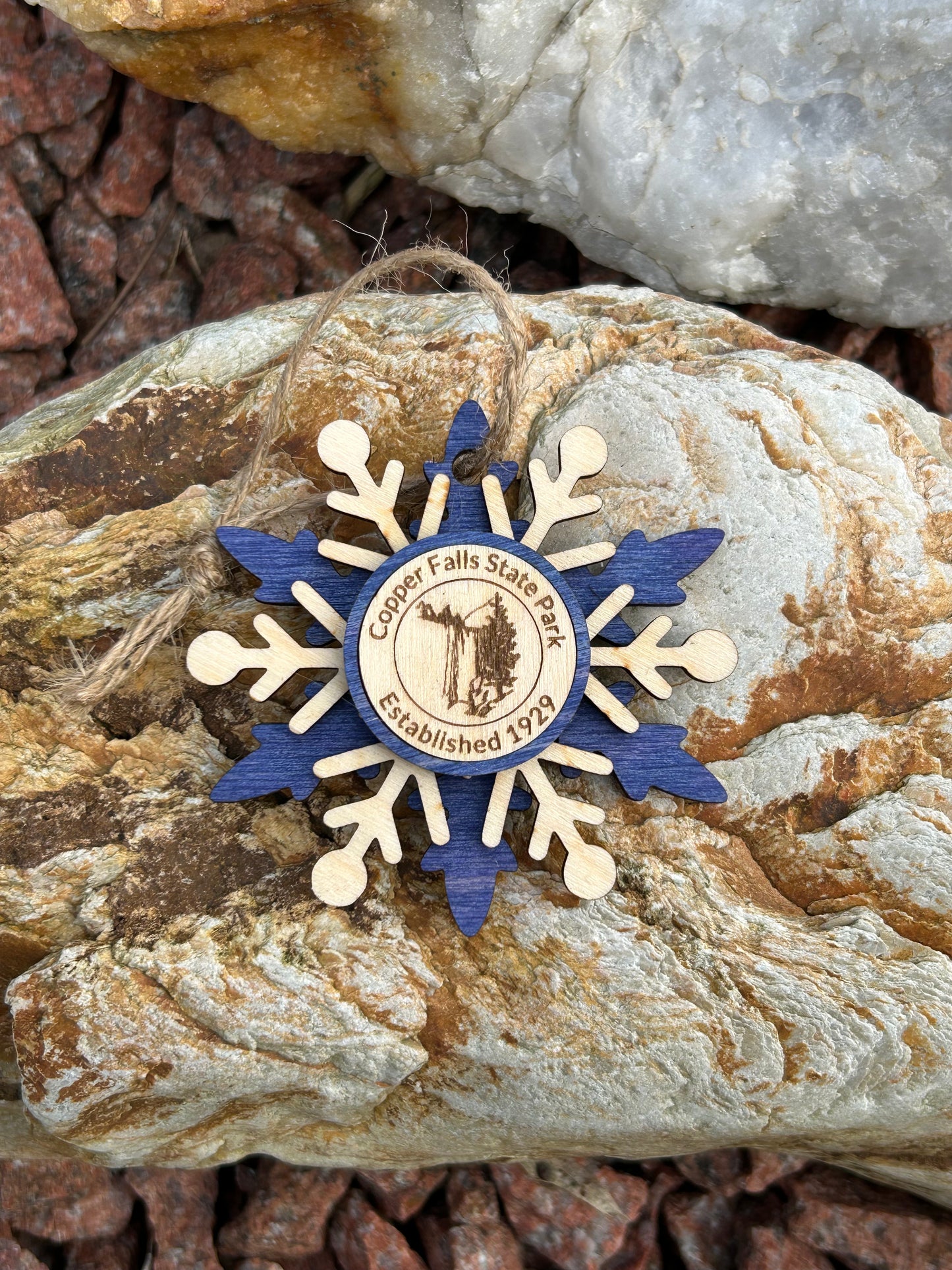 Blue wood snowflake ornament with text Copper Falls and waterfall symbol.
