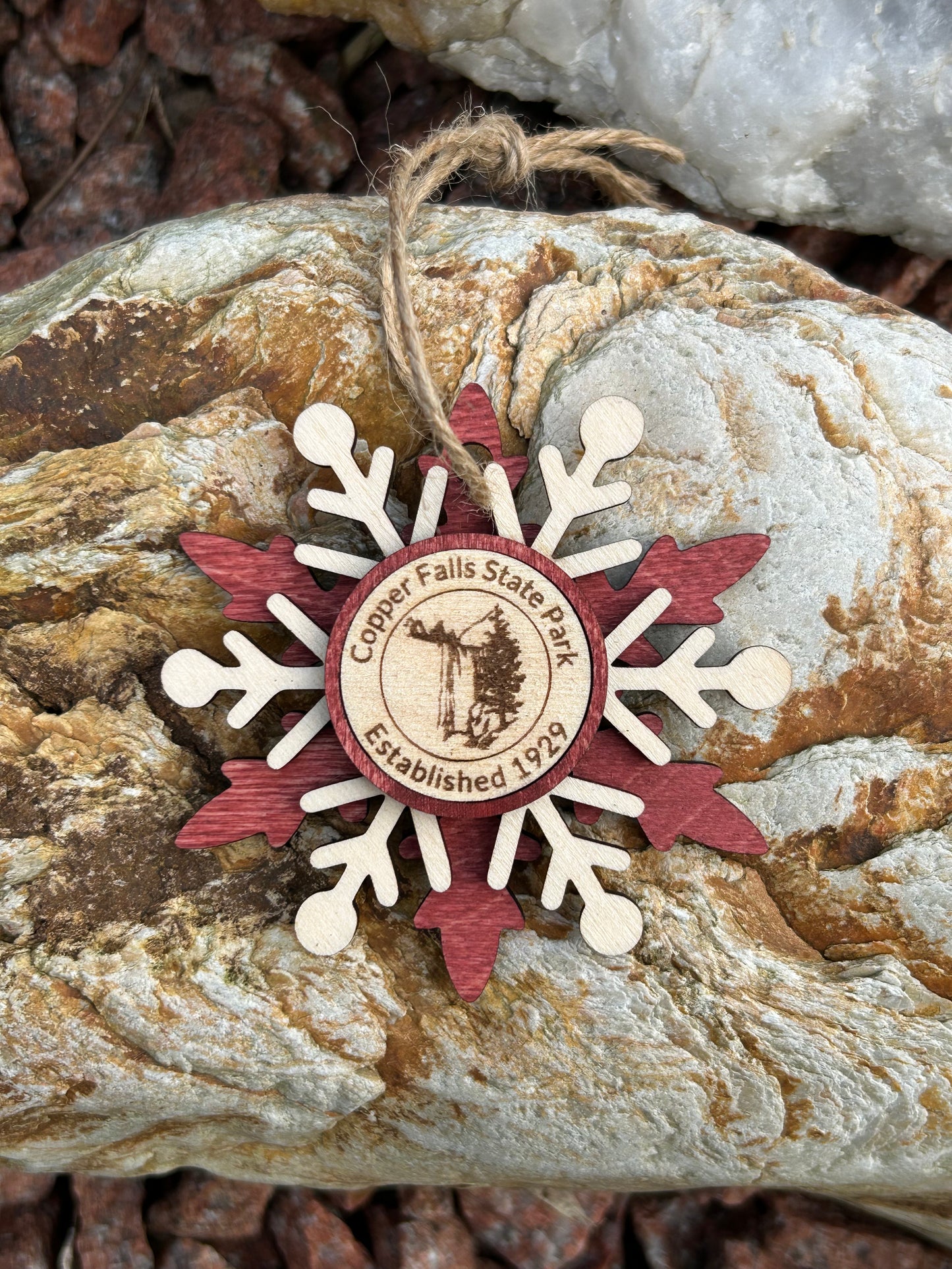 Red wood snowflake ornament with text Copper Falls and waterfall symbol.