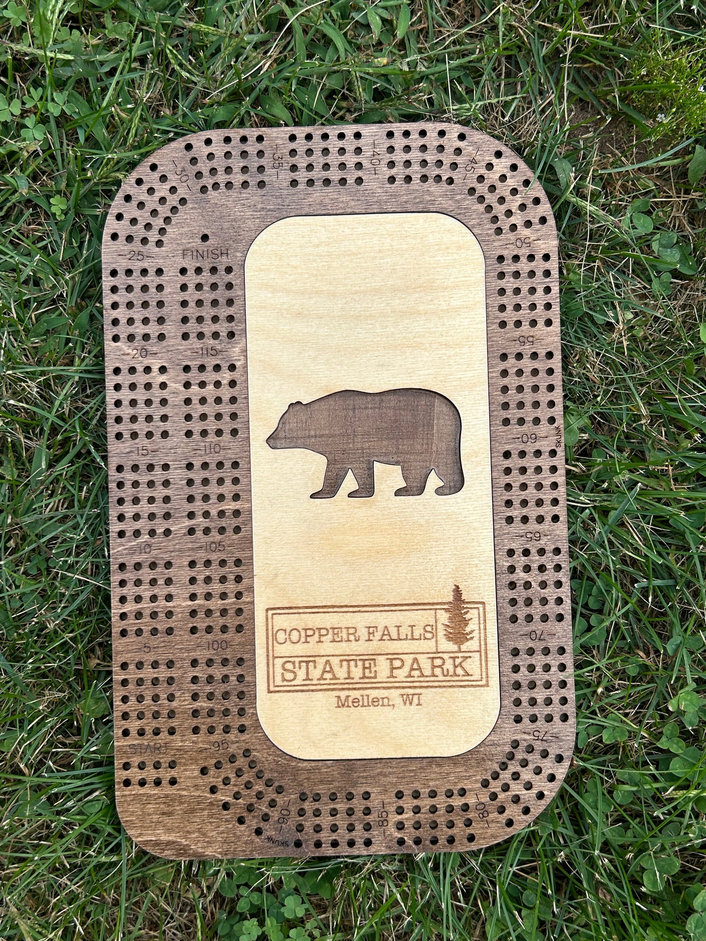 Wood cribbage board with a bear shaped cutout and Copper Falls State Park Text.