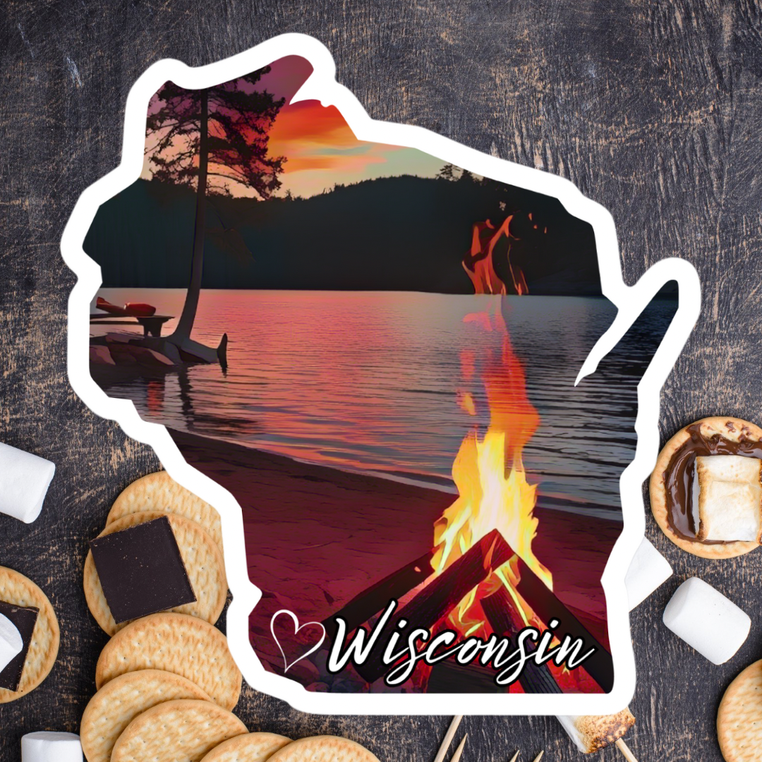 Wisconsin shaped sticker depicting a roaring campfire along a shore of a calm lake at sunset. Features a heart symbol and the text Wisconsin. Photo Background: s’mores supplies on a counter.