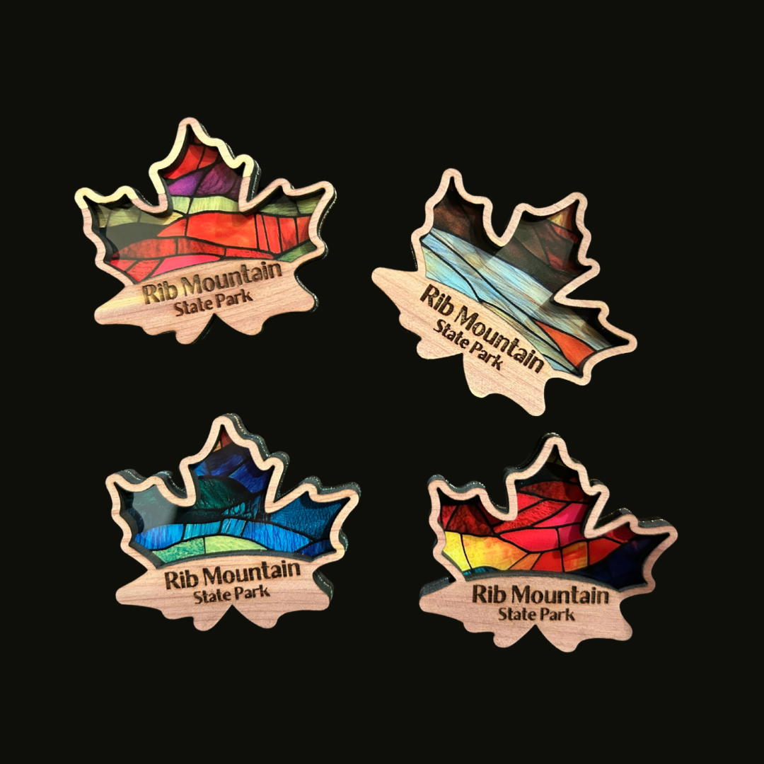 Four cedar maple leaf magnets with a faux stained glass appearance on a black background.