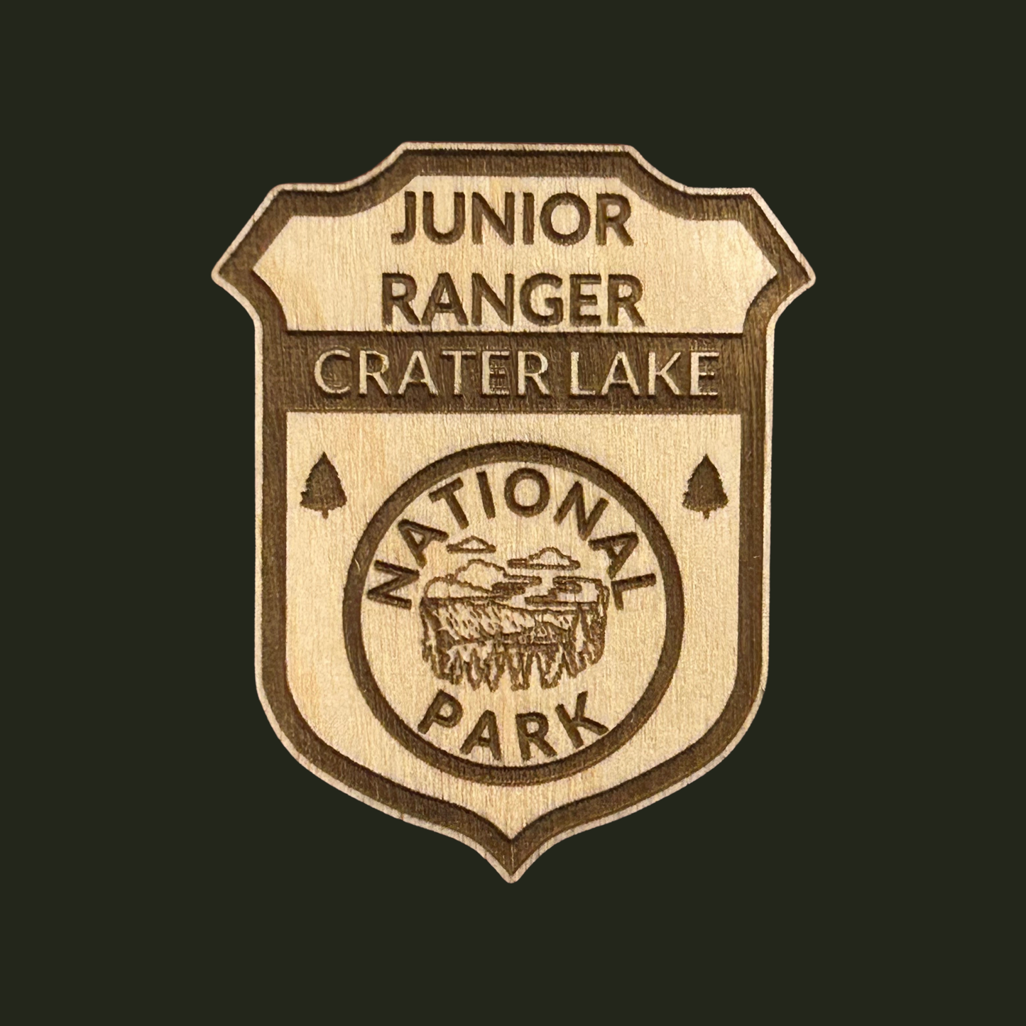 Wooden badge with 'Junior Ranger Crater Lake National Park' engraving on a black background