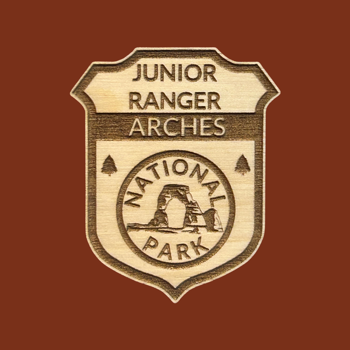 Junior Ranger Arches National Park badge on a brown background