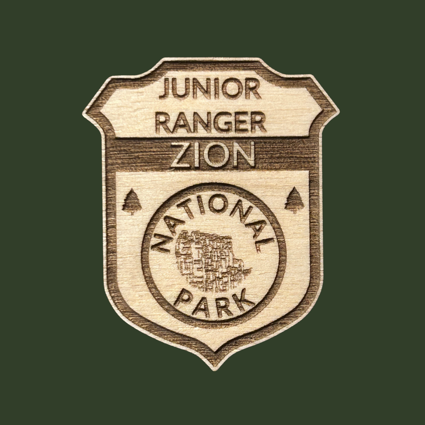 Wooden badge with 'Junior Ranger Zion National Park' text on a green background