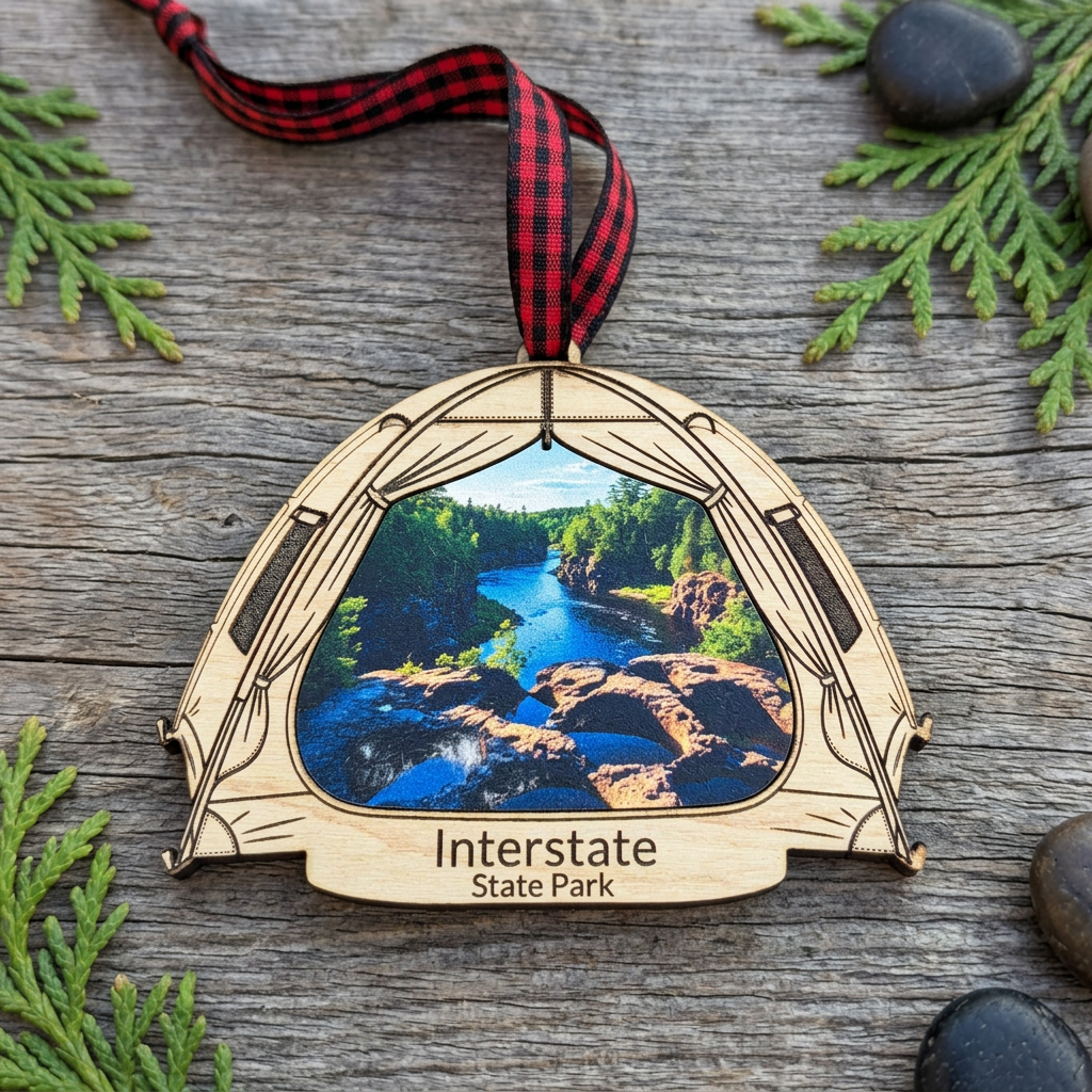 Interstate State Park tent shaped ornament laying on weathered wood with cedar boughs and wet stones.