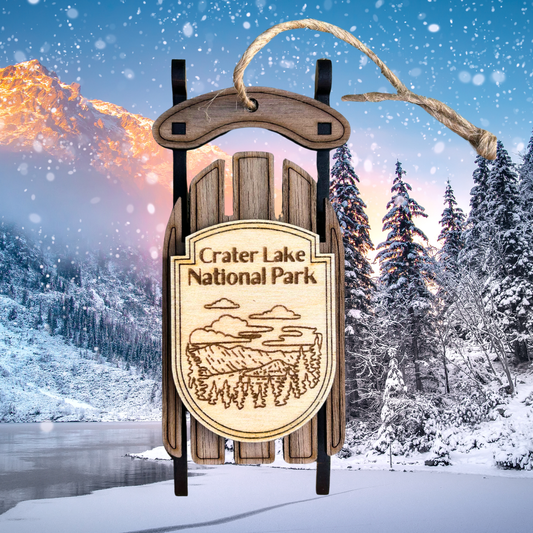 Wooden sled with Crater Lake National Park sign against a snowy landscape