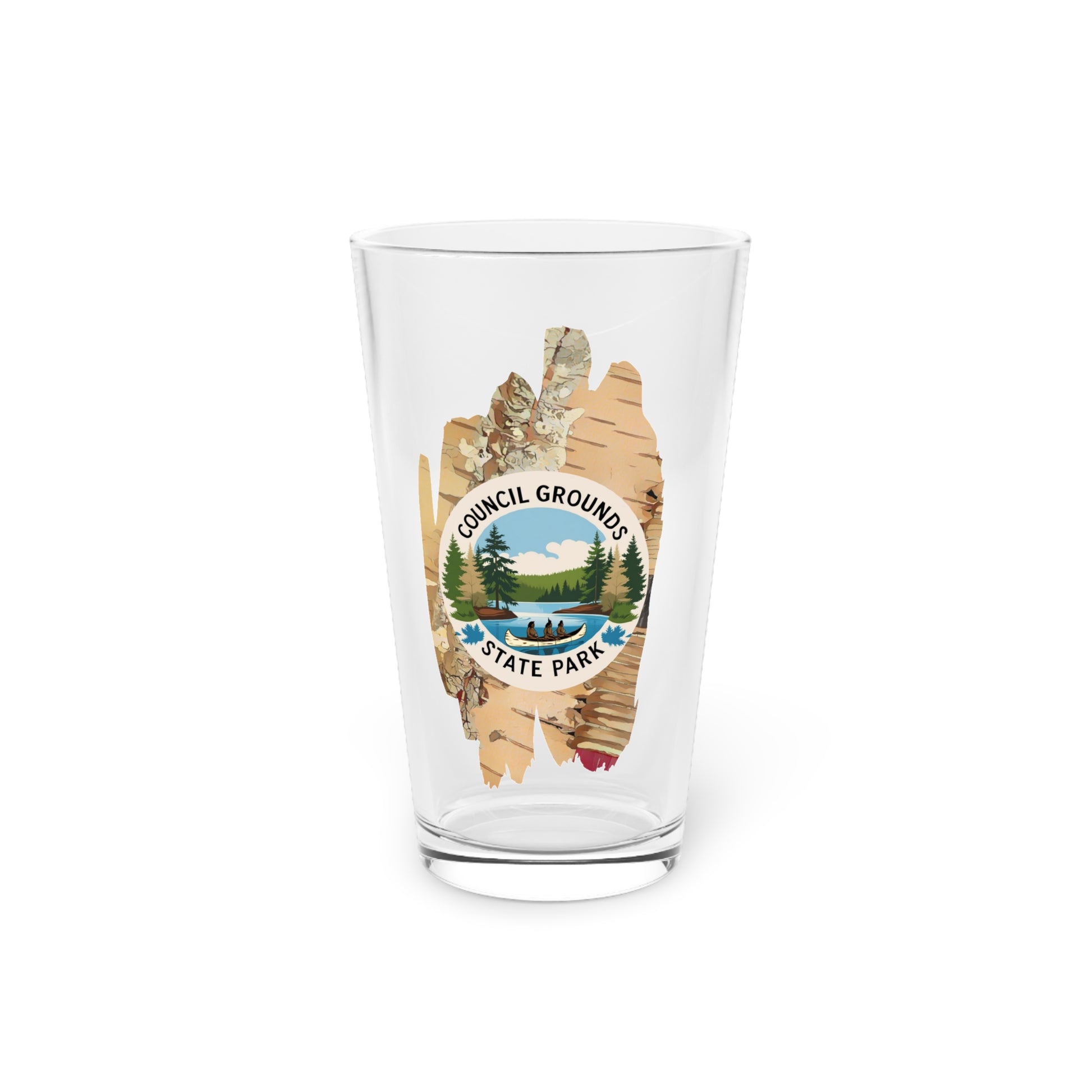 16 oz glass pint glass featuring a birch bark design with a depiction Native Americans in a birch bark canoe paddling on a river. 