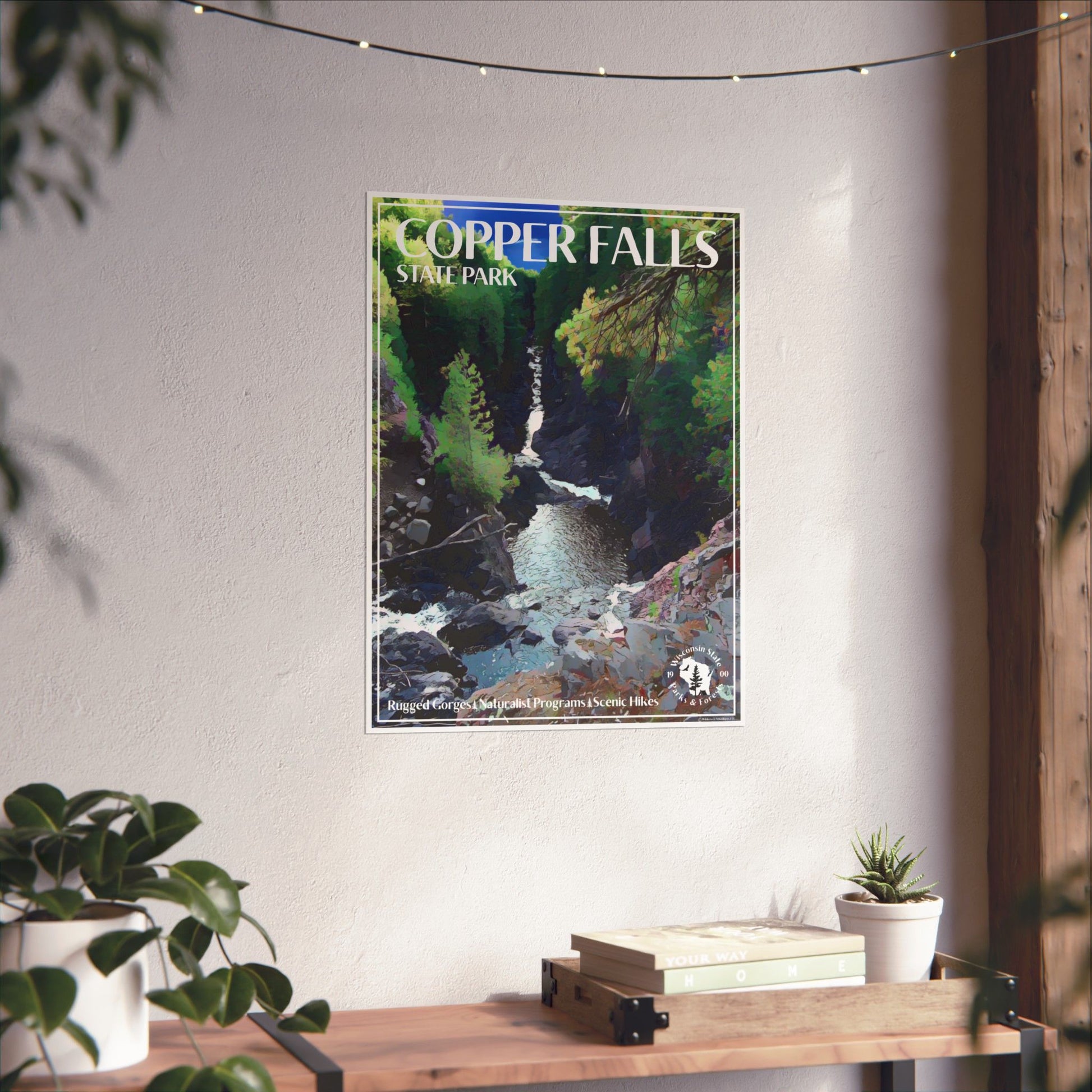 Poster with artwork of the gorge below Copper and Brownstone Falls at Copper Falls State Park.  Photo background: poster hanging on a wall above a shelf with books and potted plants.