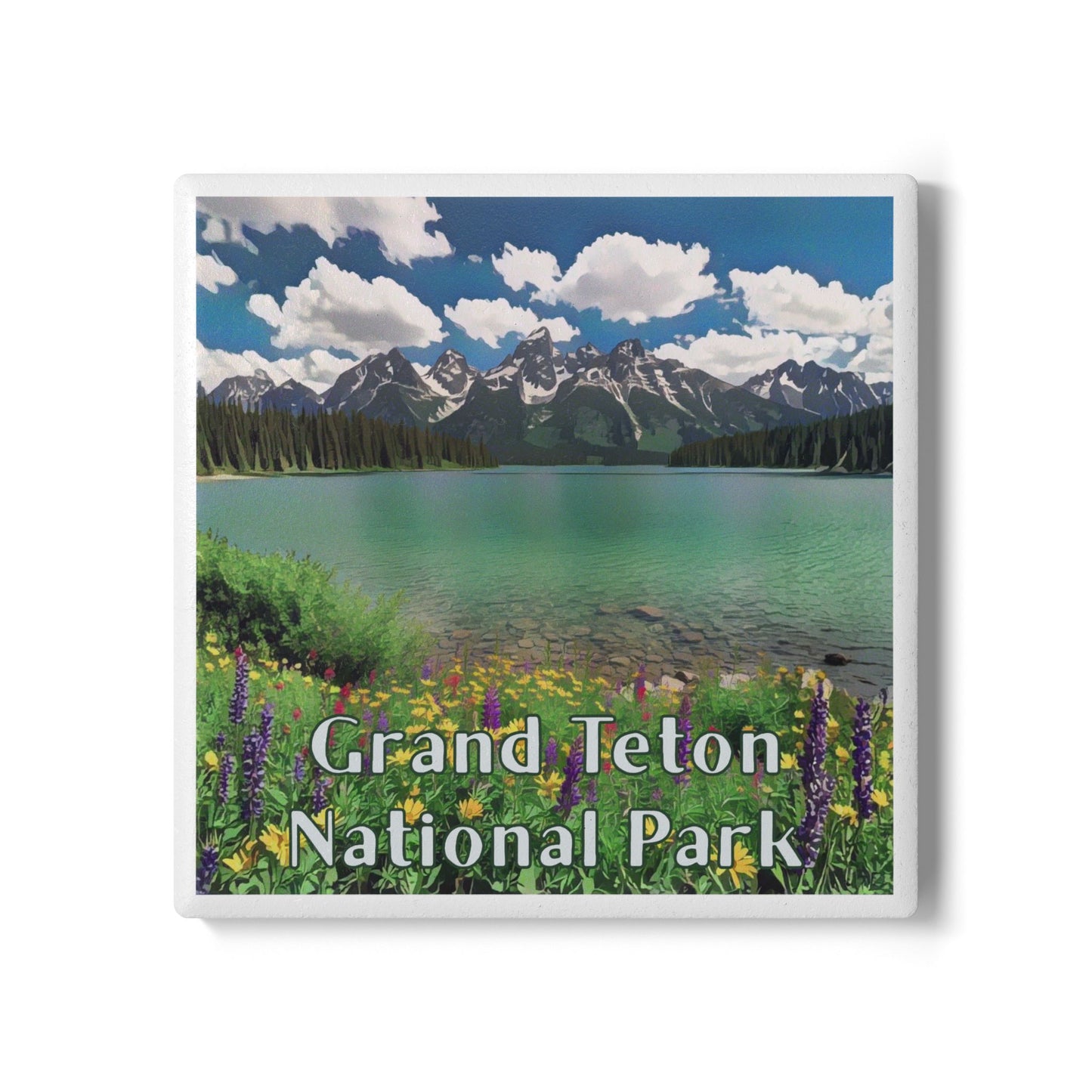 A square coaster featuring a scenic landscape of Grand Teton National Park, with turquoise lake water, snow-capped mountains, blue sky with white clouds, and wildflowers in the foreground. The text 'Grand Teton National Park' is printed across the lower portion.