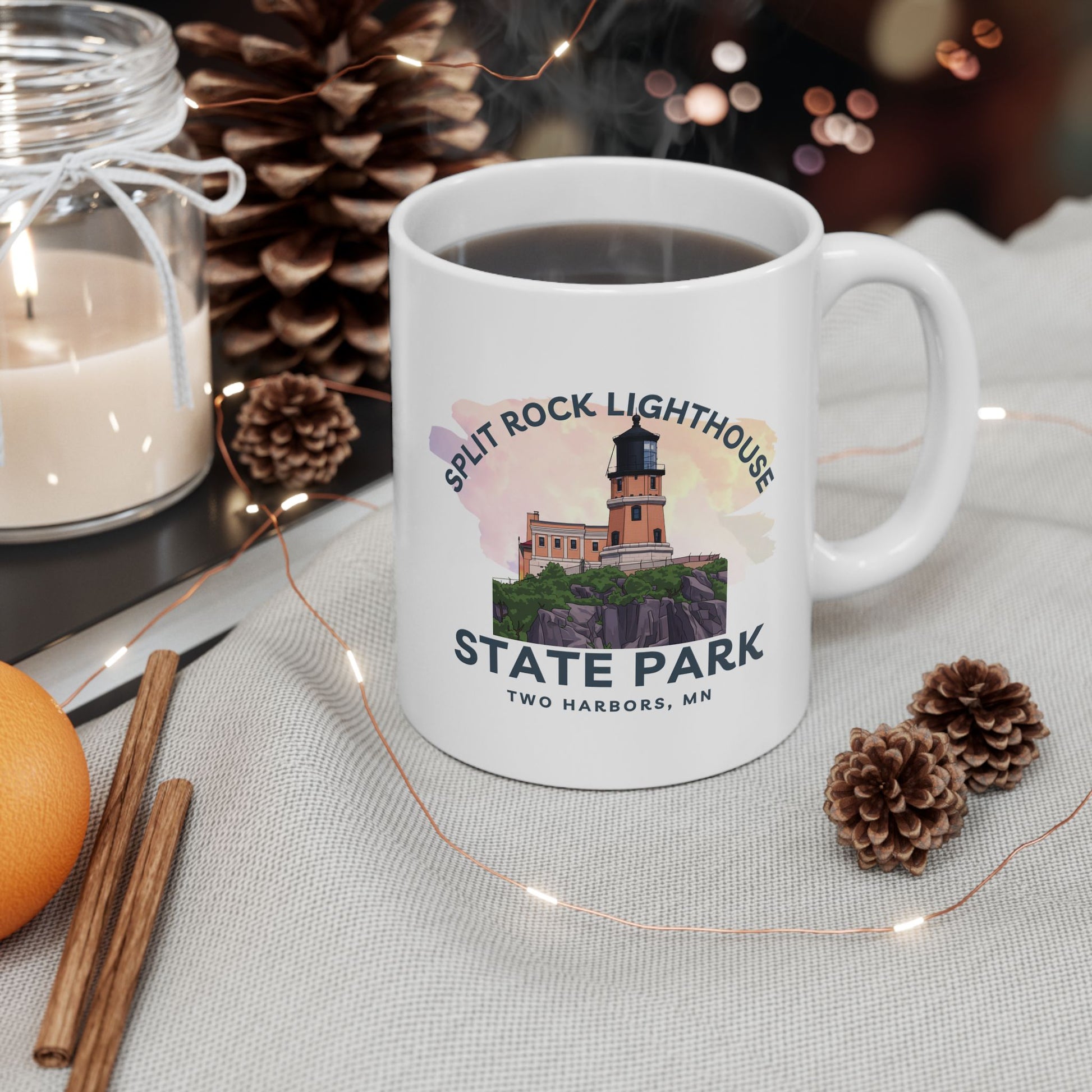 White mug with Split Rock Lighthouse State Park design on a table with decorative items.