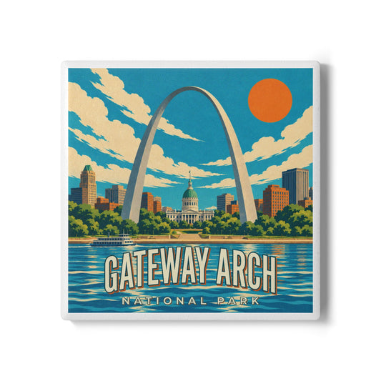 A square coaster featuring a retro-style illustration of Gateway Arch National Park, with the Gateway arch, city skyline, blue sky, clouds, water, and an orange sun. The text 'GATEWAY ARCH NATIONAL PARK' appears at the bottom.