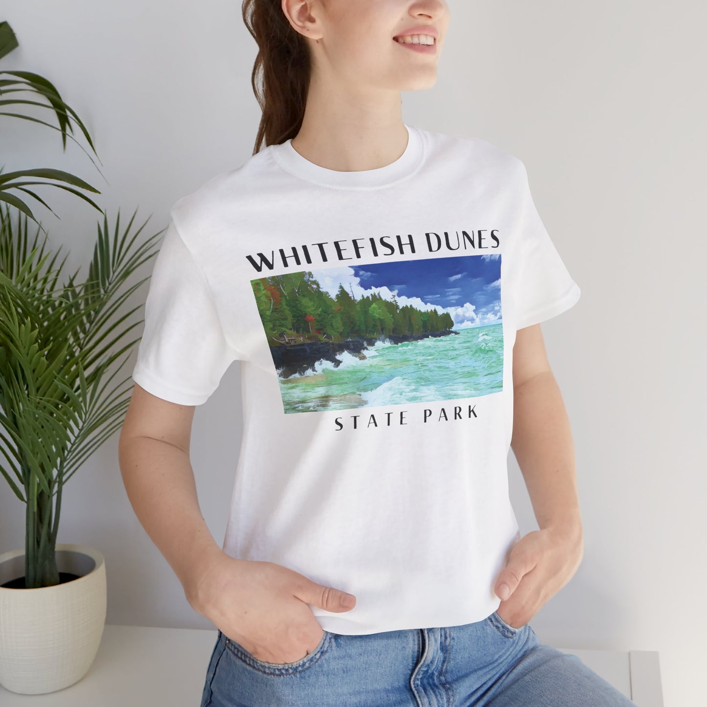 Person wearing a white t-shirt with 'Whitefish Dunes State Park' design