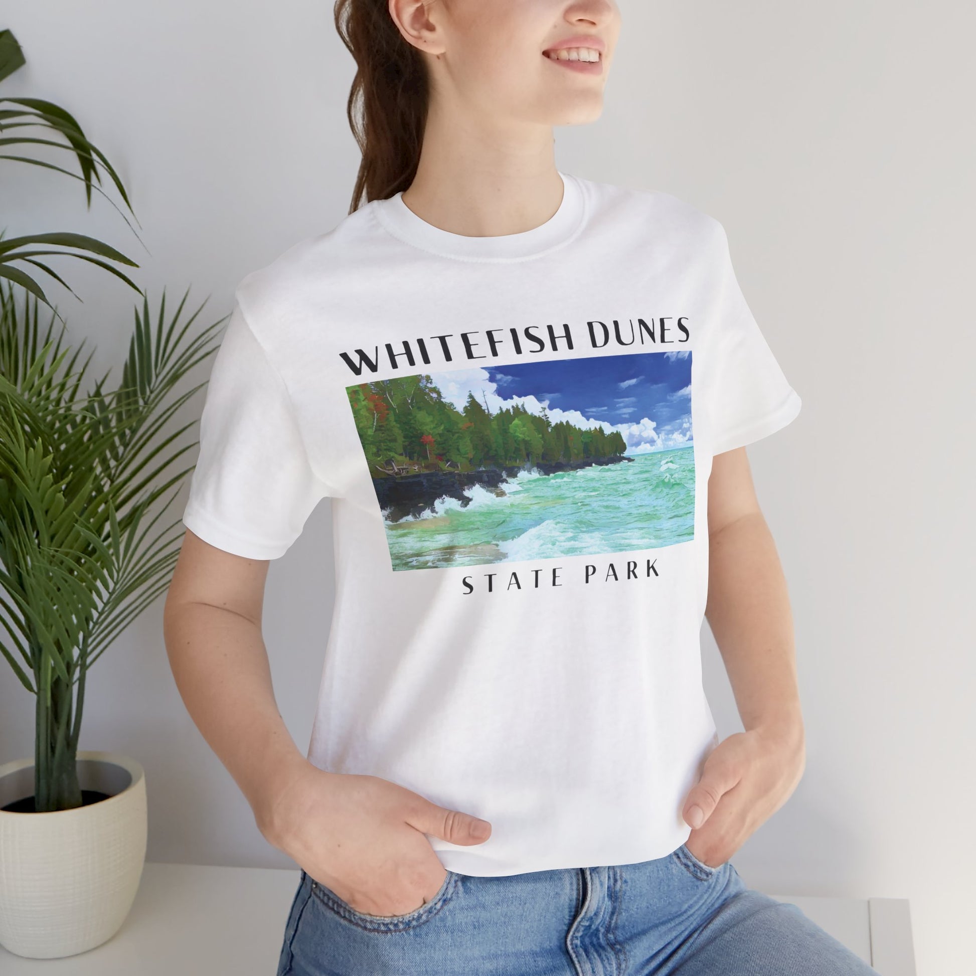 Person wearing a white t-shirt with 'Whitefish Dunes State Park' design