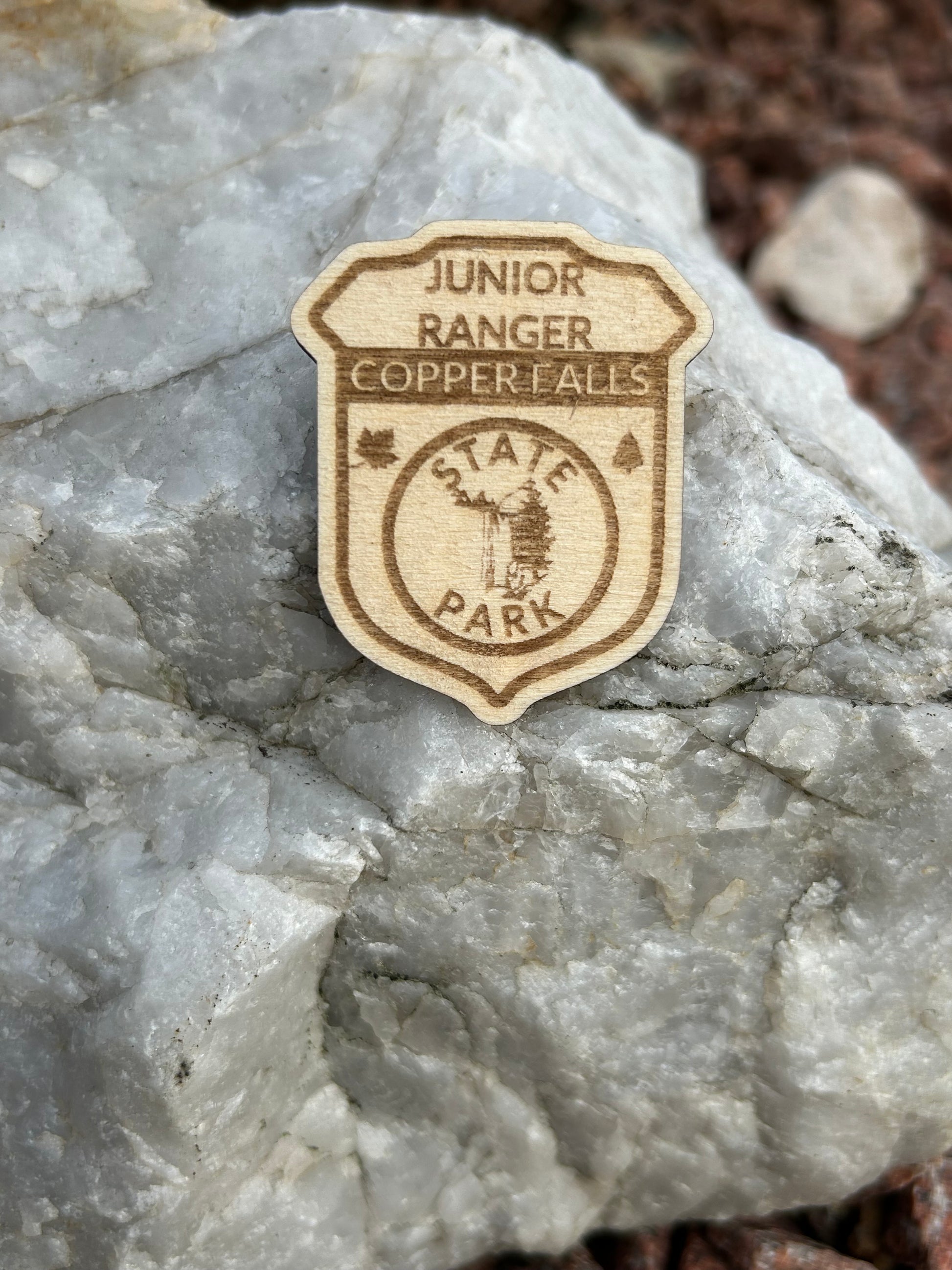 Wood badge shaped Junior Ranger Pin with Copper Falls Text and Waterfall symbol. 