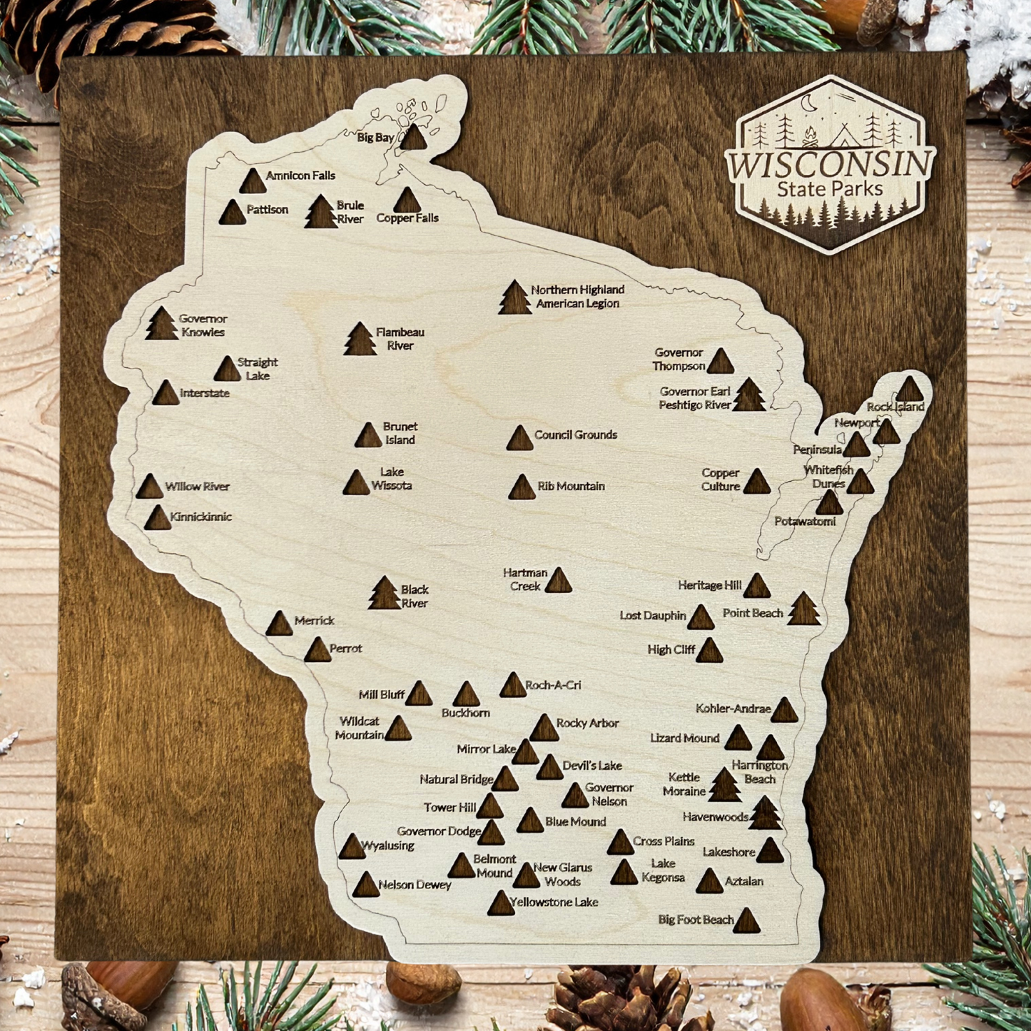 Map of Wisconsin state parks on a wooden board with decorative elements.