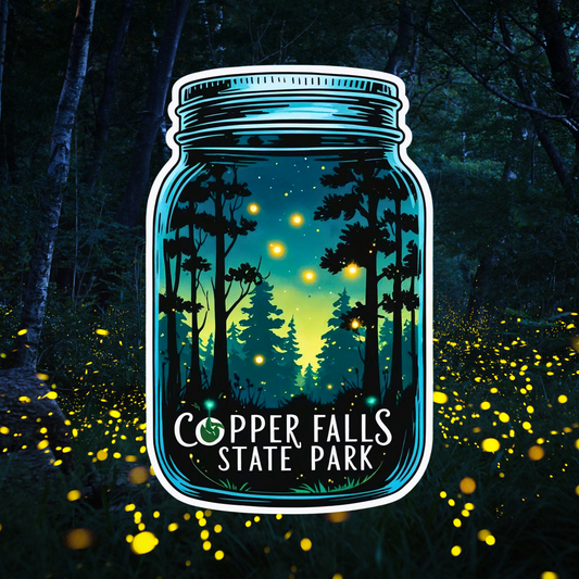 Mason jar shaped decal with a scene featuring fireflies flying around a dark forest and the text: Copper Falls State Park.  Photo background:  Fireflies in the woods.