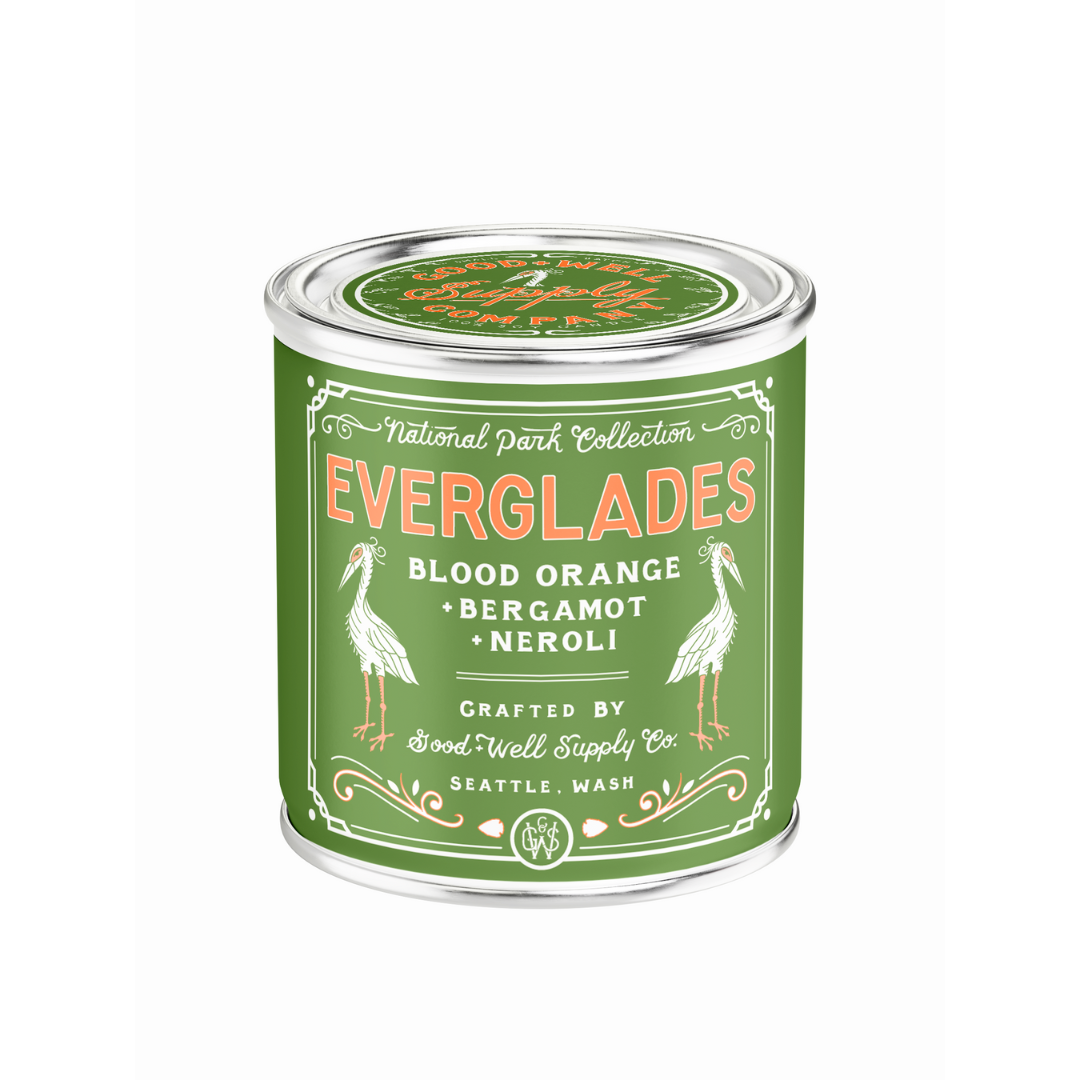 Green candle container labeled 'Everglades' with stork illustrations on a white background