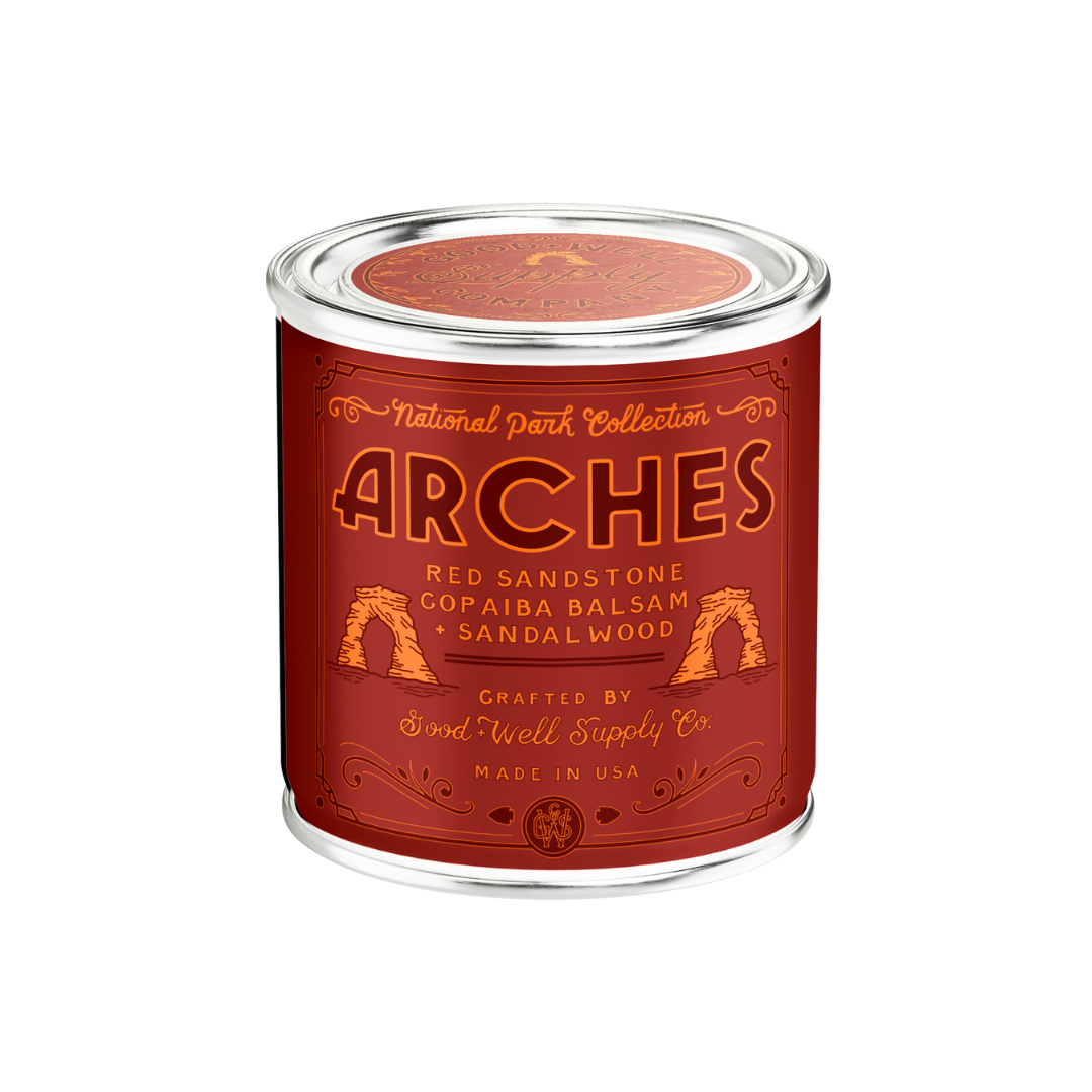 Candle in a red container with 'Arches' branding on a white background