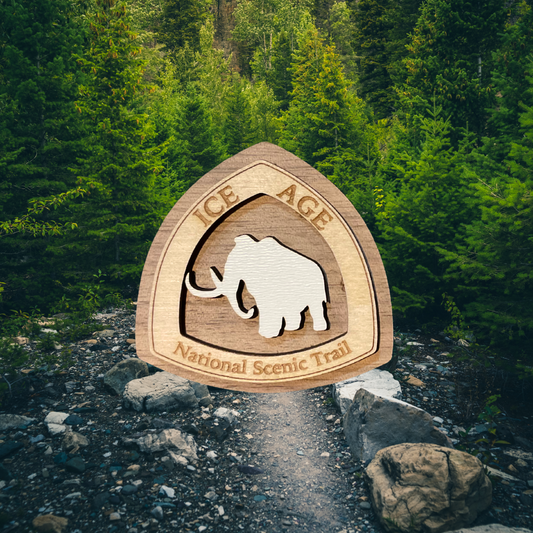 Wooden Ice Age National Scenic Trail magnet with a mammoth design in a forest setting.