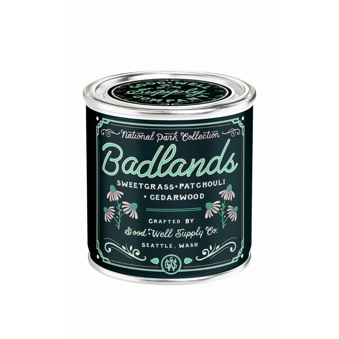 Candle tin labeled 'Badlands' with decorative text and floral designs on a white background