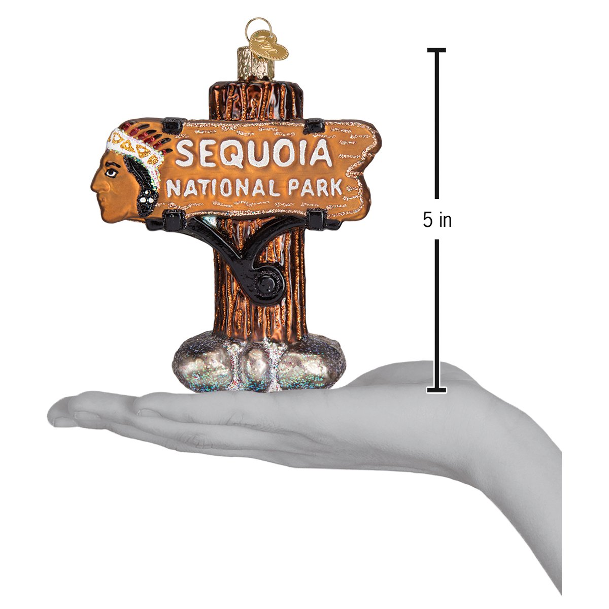 3D glass ornament in the shape of the sequoia national Park entrance sign in a person’s hand showing the size of the ornament against a white background