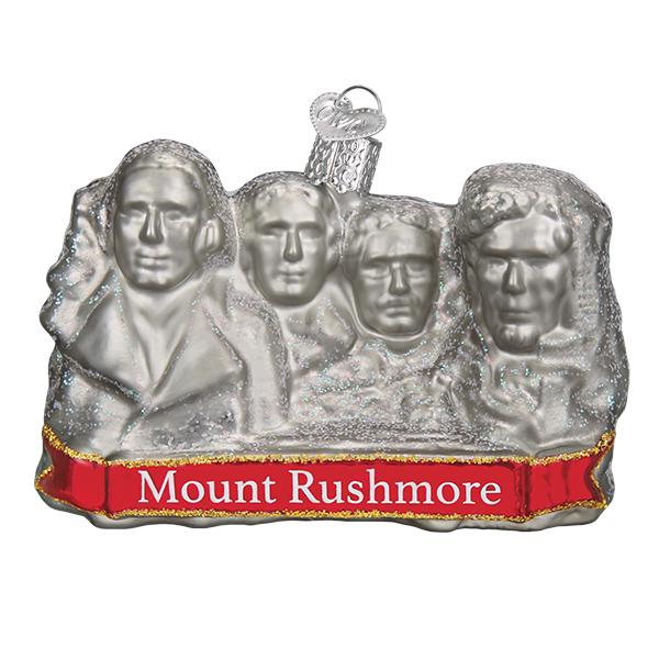 Glass ornament in the shape of Mount Rushmore on a white background.